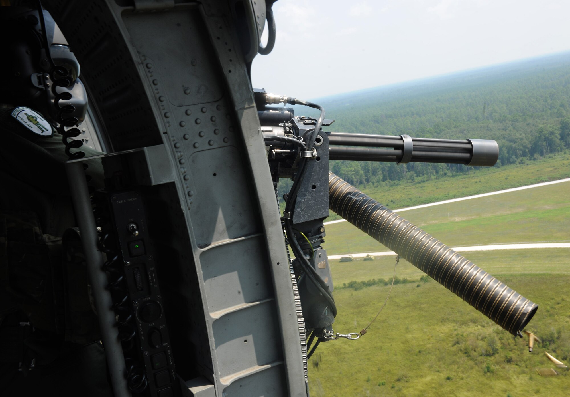 MOODY AIR FORCE BASE, Ga. -- Senior Airman David Mitchell, 41st Rescue Squadron flight engineer, fires the 7.62 mm mini-gun of an HH-60G Pave Hawk during training here Aug. 20. Red tracer munitions were fired along with regular munitions to give the aerial gunners a visual on their accuracy toward a target. (U.S. Air Force photo/Airman 1st Class Benjamin Wiseman)
