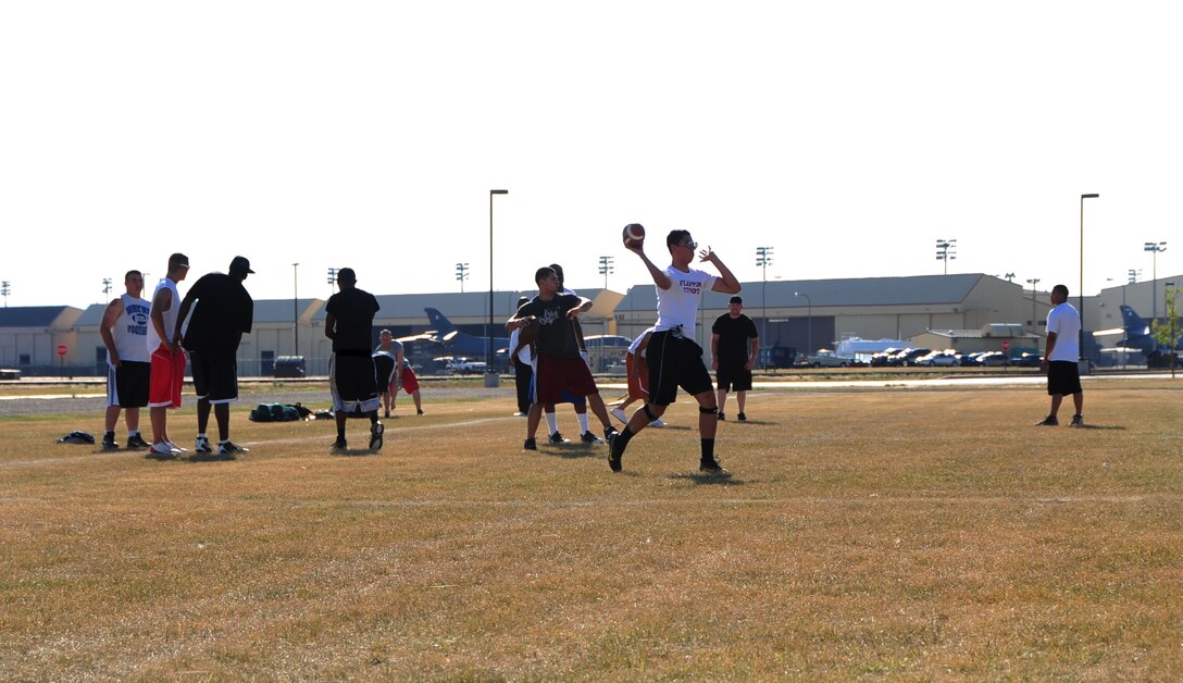 ELLSWORTH AIR FORCE BASE, S.D. -- Airmen from the 28th Civil Engineer Squadron and the Air Force Financial Services Center, work together during a football practice, Aug. 26.  The Airmen stretch before beginning their practice to reduce their chances of sustaining and injury. (U.S. Air Force photo/Airman 1st Class Anthony Sanchelli)