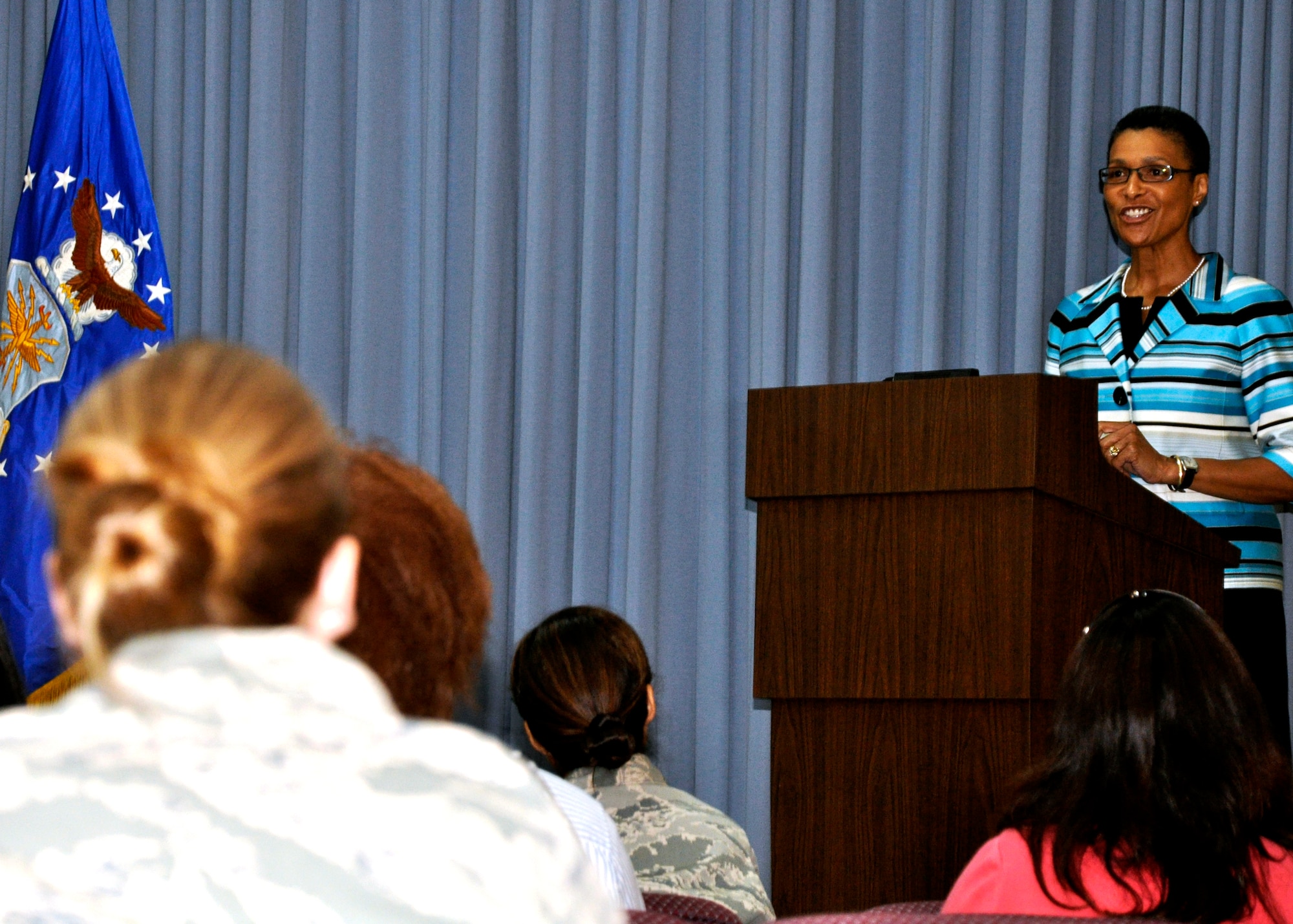 Military personnel and local community women listen on as Dr. Joyce Gossom speaks about understanding the history and fight they've faced to exercise their voting rights. Dr. Gossom, Associate Dean at the University of West Florida, was the Women's Equality Day program guest speaker at the Eglin Conference Center Aug. 26.  (U.S. Air Force photo/Wilton Glenn.)