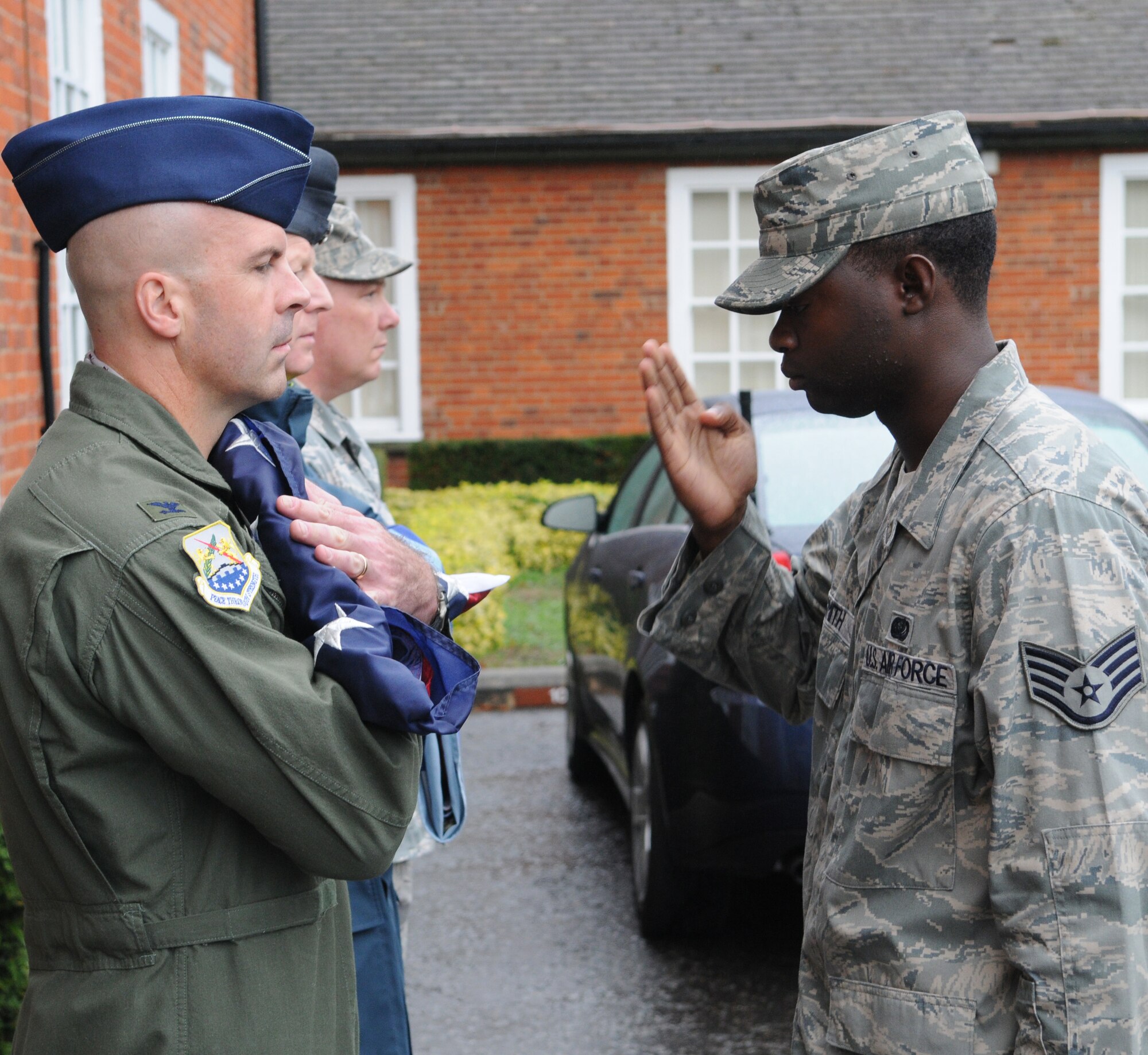 RAF MILDENHALL, England -- Staff Sgt. Juante Smith, 100th Communications Squadron, presents the colors to Col. Chad Manske, 100th Air Refueling Wing commander, in a Retreat ceremony outside the 100th ARW Headquarters Aug. 26. Airmen from the 100th Mission Support Group stood in formation to observe the Retreat. (U.S. Air Force photo/Staff Sgt. Thomas Trower)