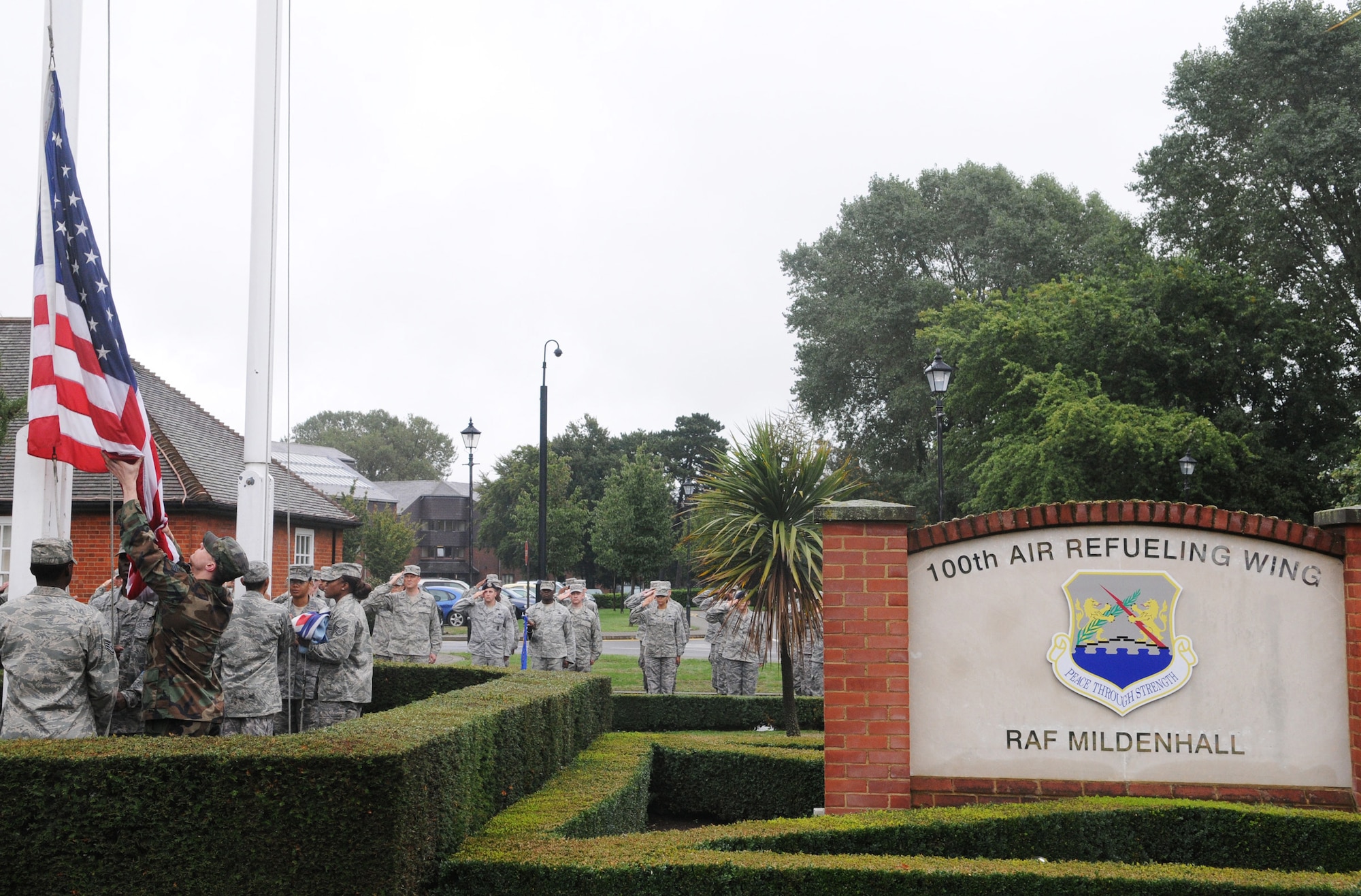 RAF MILDENHALL, England -- A formation of Airmen from the 100th Mission Support Group performs Retreat outside the 100th Air Refueling Wing Headquarters Aug. 26. A flag security detail lowers and folds the colors before presenting it to the wing commander. Retreat signals the end of the duty day while also paying respect to the flag. (U.S. Air Force photo/Staff Sgt. Thomas Trower) 