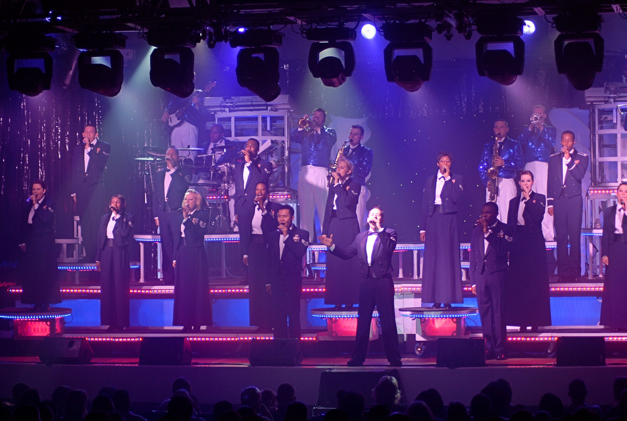 Tops in Blue performs its final number of the show in mess dress while singing the official Air Force song at Peterson Air Force Base auditorium Aug. 20. In the early to mid-1980s Tops in Blue performed in front of the Washington Monument before an audience of 400,000 for the country’s 4th of July Celebration. (U.S. Air Force photo/Airman 1st Class Jessica Hines)