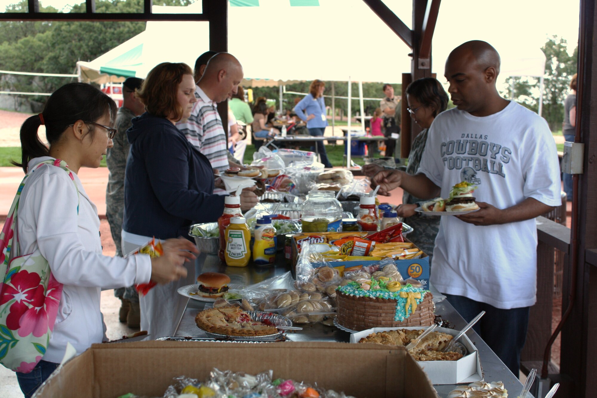Event guests take part in free food at the Deployed Families Dinner, hosted by Cheyenne Mountain Air Force Station for the first time at Mountain Man Park Aug. 6. Families enjoyed free food, prizes, activities children and transportation to and from the event from Peterson Air Force Base. (U.S. Air Force photo)