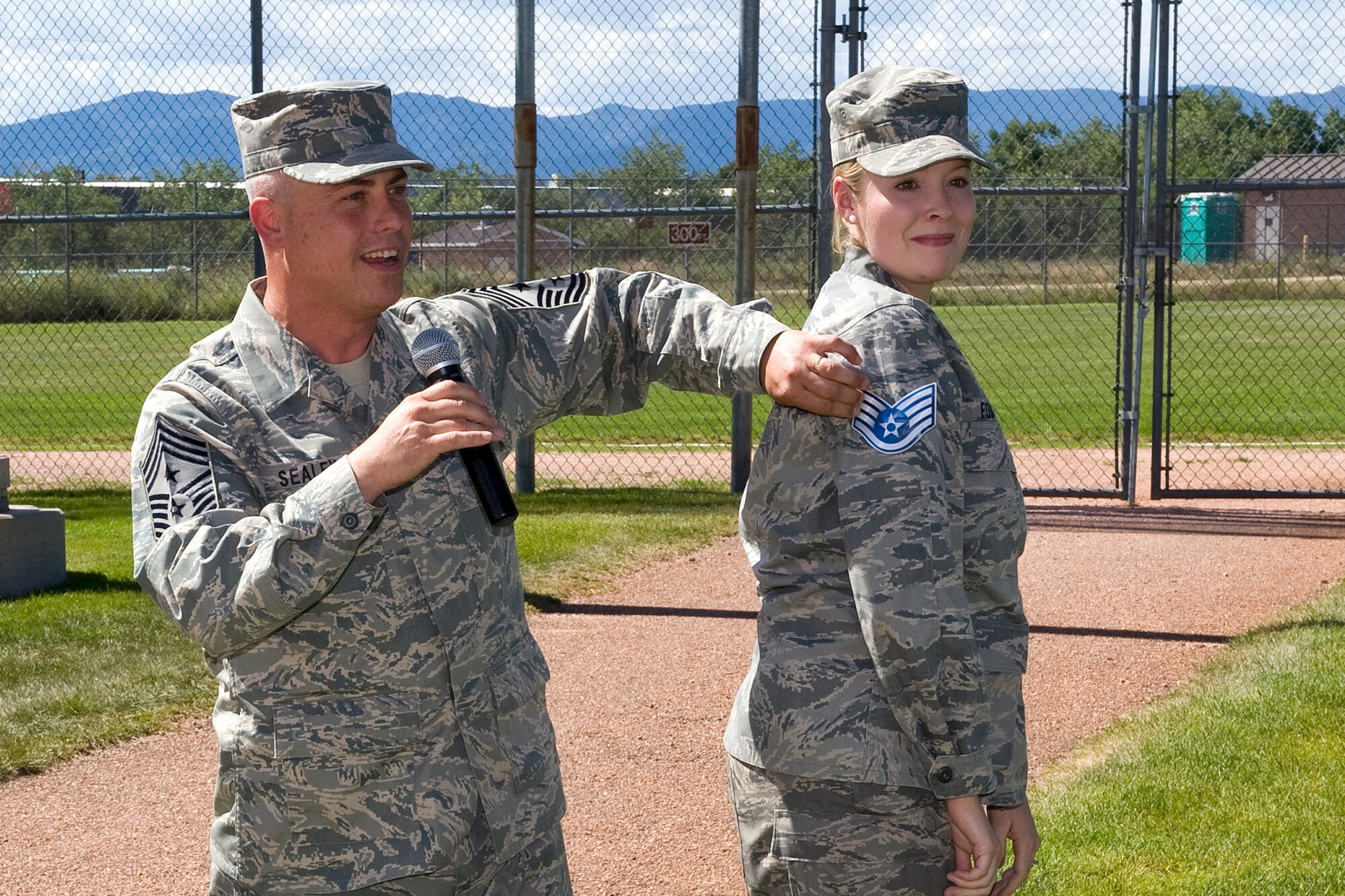PETERSON AIR FORCE BASE, Colo. -- Chief Master Sgt. Robert Sealey, 21st Space Wing command chief, shows off what new stripes will look like on Senior Airman Jennifer Fox, the chief’s executive assistant, at the recent Staff Sergeant Promotion Release Party Aug. 20. At the party, the 83 senior airmen from the 21st Space Wing and 36 senior airmen from the wing’s mission partners who will be promoted to staff sergeant were recognized. Across the Air Force, 13,518 senior airmen were promoted to staff sergeant. Those selected for staff sergeant will be promoted according to their promotion sequence number beginning in September. (U.S. Air Force photo/Craig Denton)