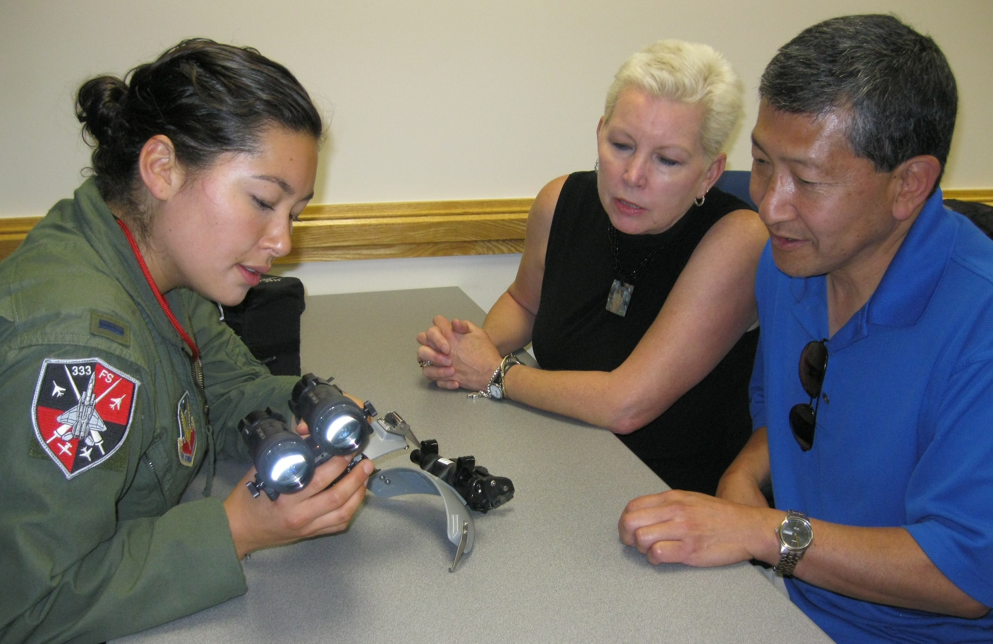 SEYMOUR JOHNSON AIR FORCE BASE, N.C. – First Lt. Kari Asai explains uses of night vision goggles to her parents, Jan and Winston Asai, during Red Carpet Day here Aug. 27, 2010. Red Carpet Day provides an opportunity for family members and guests of students in the F-15E Strike Eagle Basic-Course to learn about the training they completed and the 4th Fighter Wing mission. Lieutenant Asai graduated from the F-15E Strike Eagle Basic-Course as a weapon systems officer Aug. 28, 2010. The lieutenant is a native of Vancouver, Wash. (U.S. Air Force photo/Robin DeMark)