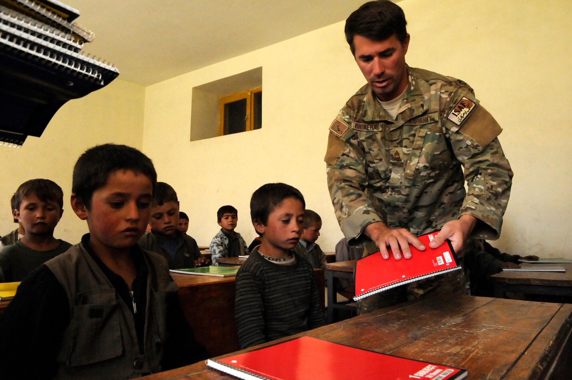 The principal of the Kur Petab boys middle school, Khenj District, expresses his gratitude after U.S. Army Master Sgt. Chad Rhinehart of Washington, N.J., Provincial Reconstruction Team Panjshir?s civil affairs noncommisioned officer in charge and U.S. Army Spc. Christopher Buckley of Old BridgU.S. Army Master Sgt. Chad Rhinehart of Washington, N.J., Provincial Reconstruction Team Panjshir?s civil affairs noncommisioned officer in charge, hands out notebooks to students who attend the Kur Petab boys middle school in Khenj District.  The notebooks were donated by numerous friends and family members of Team Panjshir.  (U.S. Air Force photo by: Tech. Sgt. Sean Mateo White PRT Panjshir photographer)   