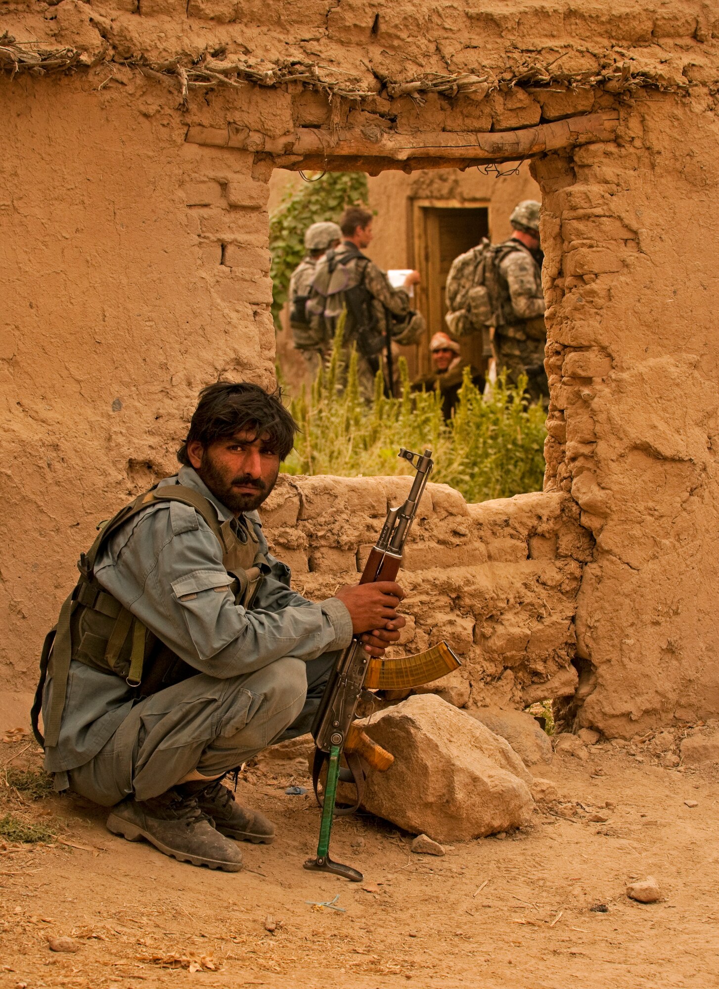 COMBAT OUTPOST MIZAN, Afghanistan - A member of the Afghan National Police sits while providing security while his team meets with local villagers during a dismounted patrol near Combat Outpost Mizan, Mizan District, Zabul province, Aug. 26. Members of 3rd Platoon, Fox Company, 2nd Squadron, 2nd Stryker Cavalry Regiment, Provincial Reconstruction Team Zabul and Afghan National Security Forces patrolled the area to meet with local elders and ensure security in the area. (U.S. Air Force Photo/Senior Airman Nathanael Callon/Released_