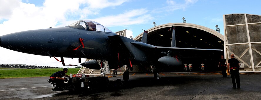 Airmen from the 67th Aircraft Maintenance Unit move an F-15 into a hangar in preparation for Typhoon Kompasu, Kadena Air Base, Japan, Aug. 30. During inclement weather such as a typhoon, aircraft and aerospace ground equipment is placed in storage for protection. (US Air Force photo/Staff Sgt. Christopher Hummel)