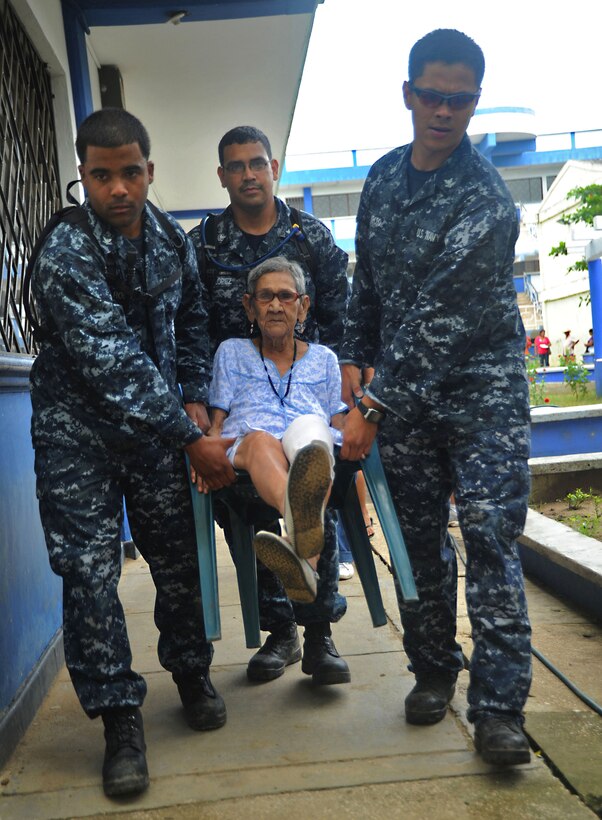 U.S. Navy Petty Officer 2nd Class Mario Lopez, 2nd Class Oliver Arceo, 3rd Class Enrique Rodriguez, all three embarked aboard USS Iwo Jima, carry an elderly woman to a clinic during a Continuing Promise 2010 medical community service event, Colombia, Aug. 9, 2010. Iwo Jima is operating off the coast of Colombia supporting the Continuing Promise  humanitarian and civic assistance mission.