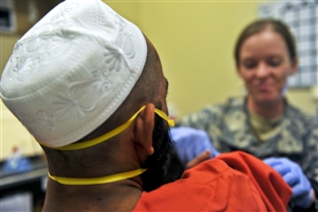 A U.S. Army soldier provides medical care to a detainee at the U.S.-operated detention facility in Parwan, Afghanistan, Aug. 23, 2010. Defense Department officials allowed news media representatives to take video and still photos in the facility for the first time since the facility became operational in December 2009. Afghan officials will begin to take over the facility in 2011.