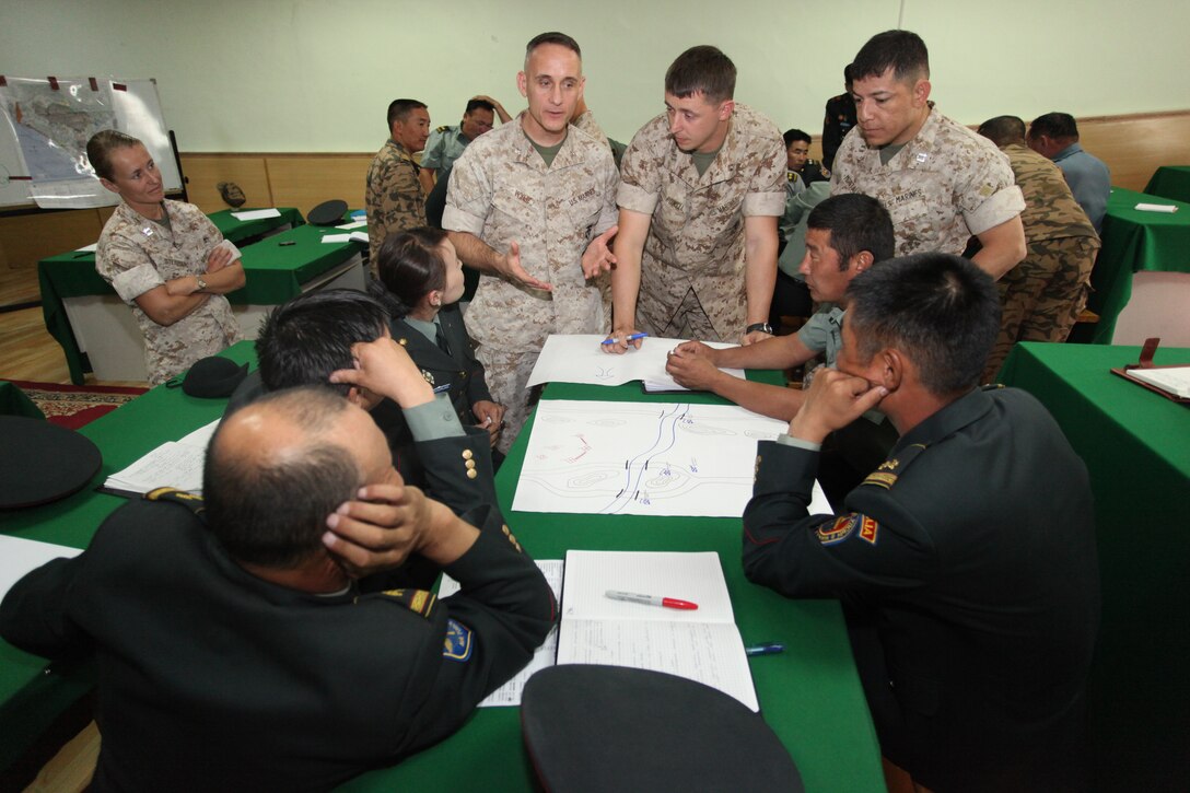 Lt. Col. Michael Wylie teaches the Marine Corps planning process Aug. 29 at the Defense University of Mongolia. Ten officers and enlisted Marines with the 11th Marine Expeditionary Unit visited the country Aug. 27 to Sept. 4 to exchange best warrior practices with the Mongolian military. Wylie, the unit's executive officer, is joined by, from left, Capts. Dawn M. Steinberg, Justin Powell and Jose L. Montalvan.