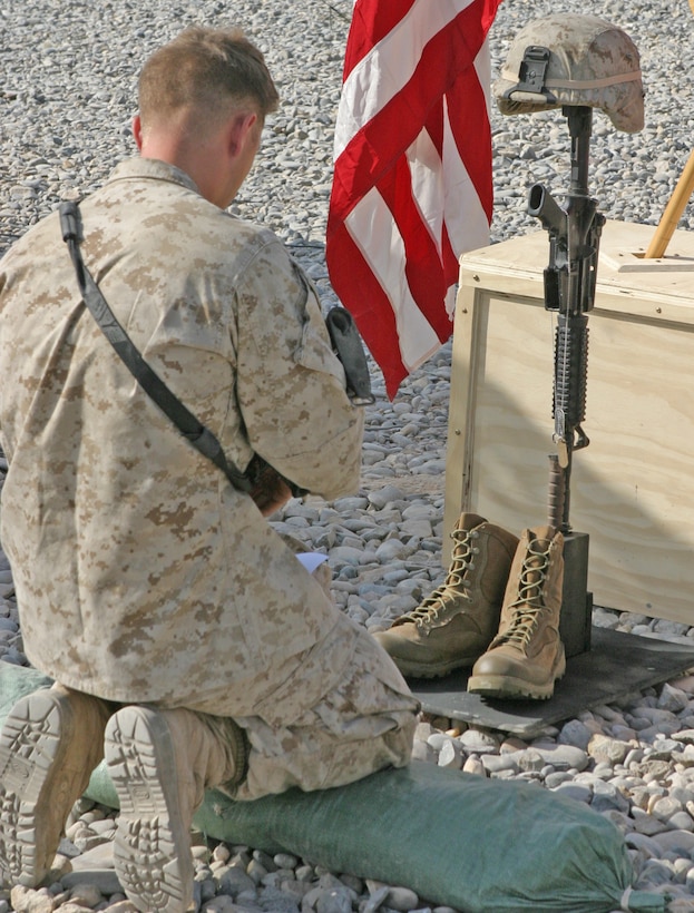 A Marine with 2nd Battalion, 9th Marine Regiment, pays his respects to Petty Officer 3rd Class James M. Swink II, a hospital corpsman with Golf Company, 2/9, during a memorial service at Combat Outpost Reilly, Marjah, Afghanistan, Aug. 31. Swink was killed, Aug. 27, while conducting combat operations in Helmand province, Afghanistan.