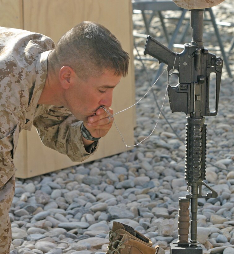 A Marine with 2nd Battalion, 9th Marine Regiment, pays his respects to Petty Officer 3rd Class James M. Swink II, a hospital corpsman with Golf Company, 2/9, during a memorial service at Combat Outpost Reilly, Marjah, Afghanistan, Aug. 31. Swink was killed, Aug. 27, while conducting combat operations in Helmand province, Afghanistan.