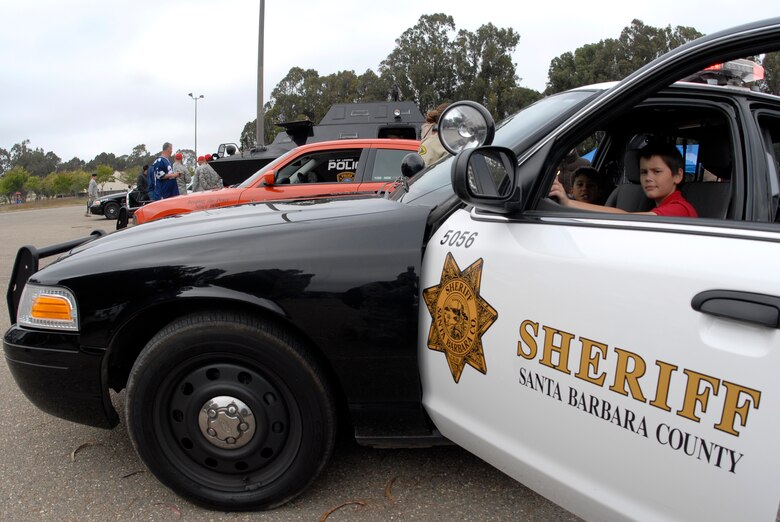 VANDENBERG AIR FORCE BASE, Calif. -- Justin Wells pretends to stop criminals in  a Santa Barbara County Sheriff's  Department patrol vehicle during the National Night Out Against Crime event here Friday, Aug. 27, 2010.  Many law enforcement agencies from the local area and from the base participated in the event to educate people on deterrence and crime prevention.  (U.S. Air Force photo/Senior Airman Andrew Satran) 

 
 
 