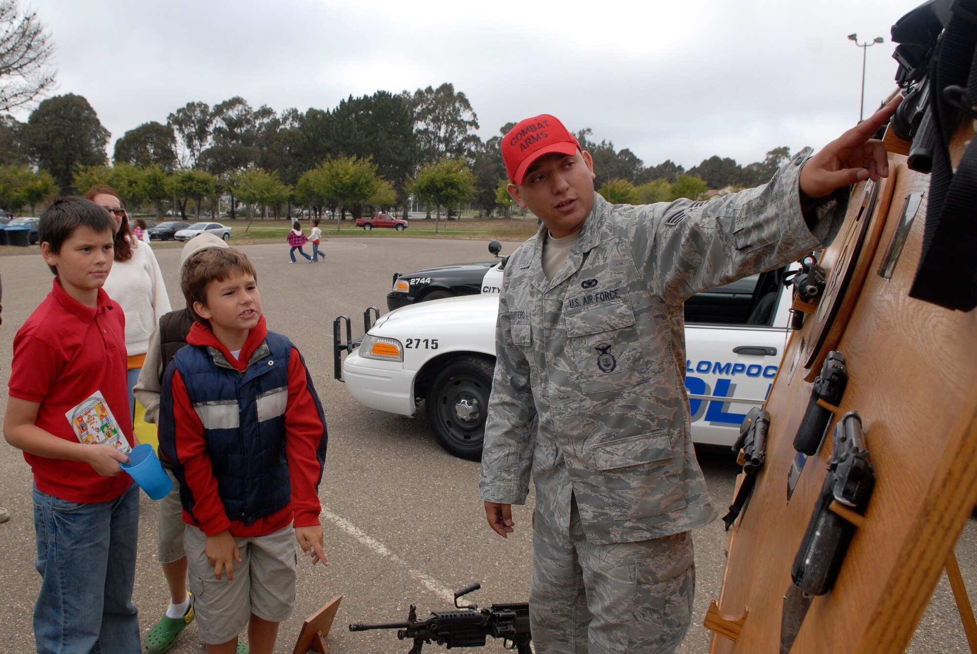 VANDENBERG AIR FORCE BASE, Calif. -- Senior Airman Gino Carruitero, a 30th Security Forces Squadron combat arms training and maintenance instructor, educates military dependents on the M203 machine gun here Friday, Aug. 27, 2010.  The National Night Out Against Crime event was hosted by the 30th SFS. (U.S. Air Force photo/Senior Airman Andrew Satran) 

 
 