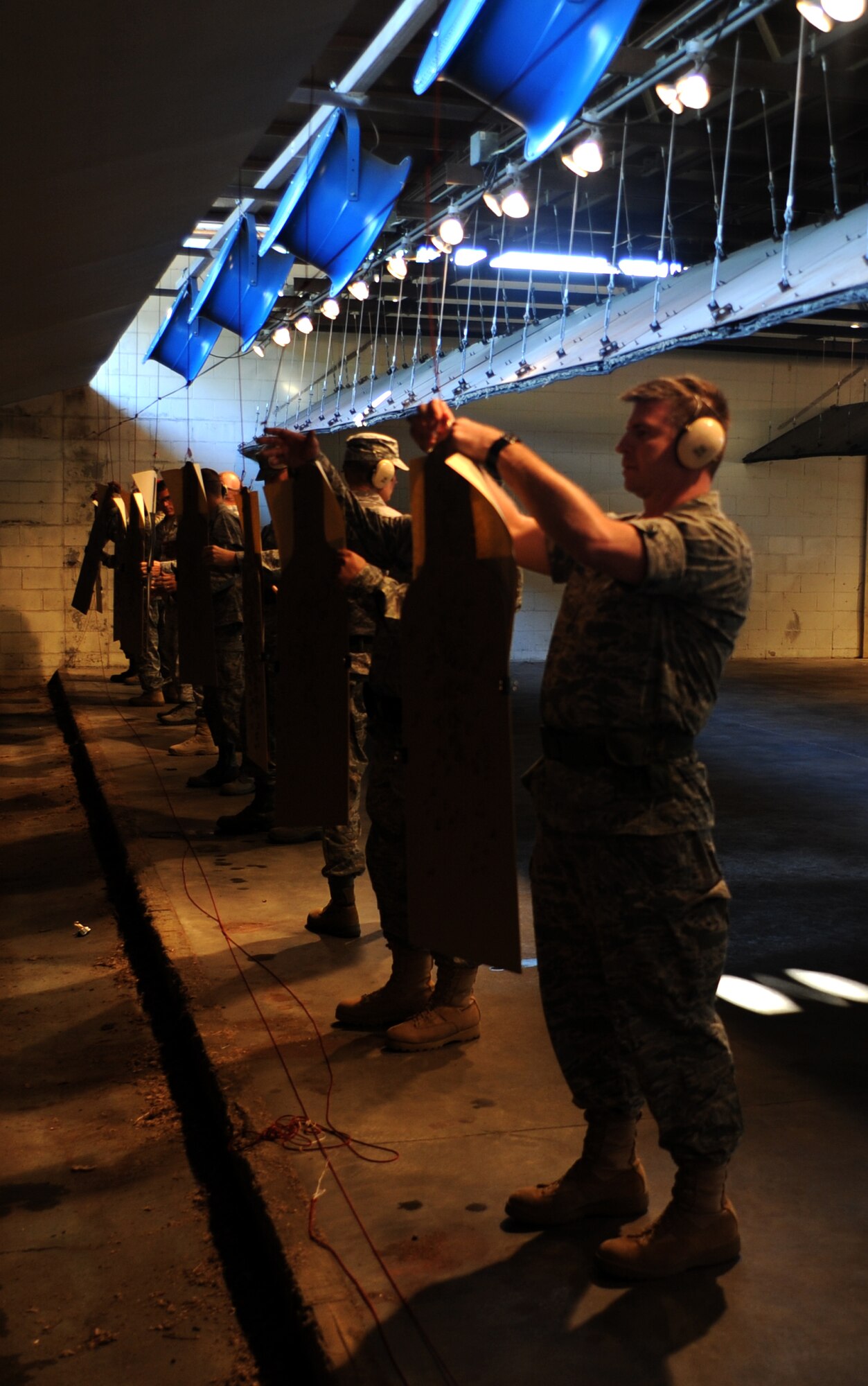 Shooters attach their targets at the 25-meter mark for their final magazine at the Combat Arms Training and Maintenance range facility's opening ceremony Aug. 31, 2010, on Joint Base Charleston, S.C. The improved range has 30 fans that blow gun smoke down and out the range, making it well ventilated so instructors and students don't inhale the smoke. The new and improved range also includes spotlights to illuminate targets down the range. (U.S. Air Force photo/Senior Airman Timothy Taylor)