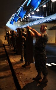 Shooters attach their targets at the 25-meter mark for their final magazine at the Combat Arms Training and Maintenance range facility's opening ceremony Aug. 31, 2010, on Joint Base Charleston, S.C. The improved range has 30 fans that blow gun smoke down and out the range, making it well ventilated so instructors and students don't inhale the smoke. The new and improved range also includes spotlights to illuminate targets down the range. (U.S. Air Force photo/Senior Airman Timothy Taylor)
