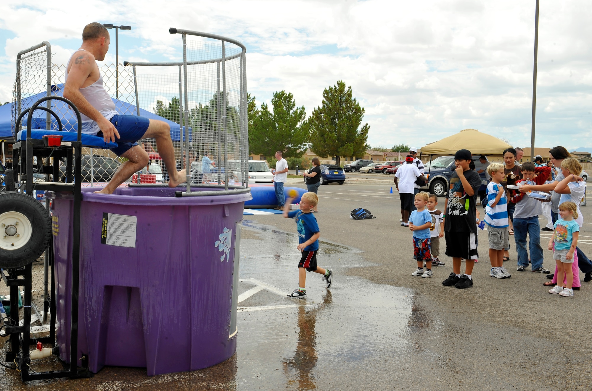 HOLLOMAN AIR FORCE BASE, N.M. -- Master Sgt. Jason Williams, 49th Maintenance Operation Squadron first sergeant, sits in a water dunk tank as children aim for the target during the Young Heroes Deployment Expo Aug. 28, 2010. The expo featured carnival games, bouncy castles, free pizza and a hero-pack ceremony where they gave Holloman's youngest heroes a care package, dog tags and a certificate of appreciation. (U.S. Air Force photo by Senior Airman Veronica Stamps / Released)