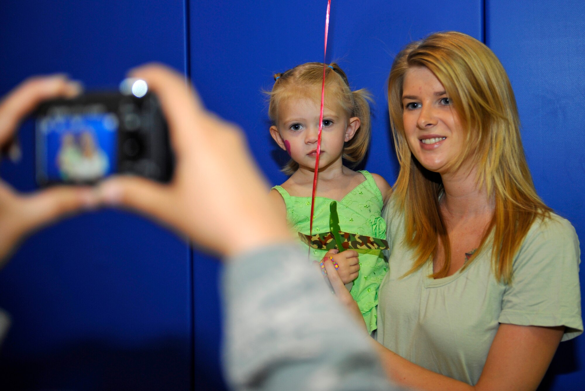 HOLLOMAN AIR FORCE BASE, N.M. -- Aubree Downs, daughter of Senior Airman Philip Downs, 49th Maintenance Squadron, poses for a picture with her mom, Lindy, during the Young Heroes Deployment Expo Aug. 28, 2010. Pictures on pillowcases were provided for children of all ages to give to their parents who are preparing to leave or who are currently deployed. The expo featured carnival games, bouncy castles, free pizza and a hero-pack ceremony where they gave Holloman's youngest heroes a care package, dog tags and a certificate of appreciation. (U.S. Air Force photo by Senior Airman Veronica Stamps / Released)