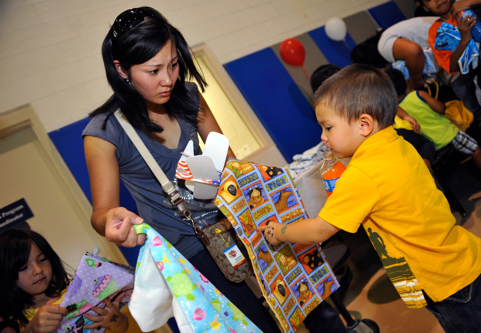 HOLLOMAN AIR FORCE BASE, N.M. -- Rei Testa helps her son Kodai pick out a pillowcase for his dad, Staff Sgt. Mikhail Testa, 49th Aircraft Maintenance Squadron at the Young Heroes Deployment Expo Aug. 28, 2010. Pictures on pillowcases were provided for children of all ages to give to their parents who are preparing to leave or who are currently deployed. The Airman and Family Readiness Center hosted the event to honor all family members of deployed Airmen. (U.S. Air Force photo by Senior Airman Veronica Stamps / Released)