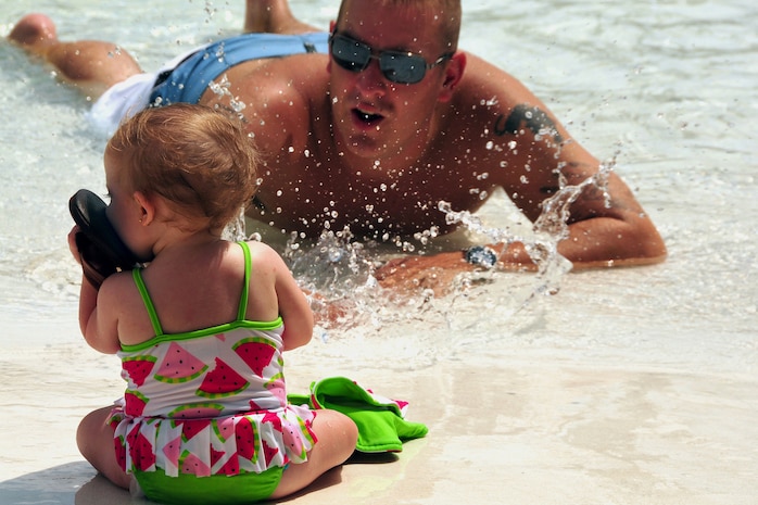 Ryleigh Lurvey finds a new toy for teething while her father, U.S. Air Force Senior Airman Jacob Lurvey, vies for her attention at the base pool on Joint Base Charleston, S.C., Aug. 28, 2010. Airman Lurvey attended the event his wife, son, daughter and a few neighborhood children after hearing about the event through the Youth Programs Center. Airman Lurvey is a radio frequency transmission system technician with the 628th Communications Squadron. (U.S. Air Force photo/Staff Sgt. Daniel Bowles)