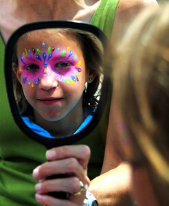 Sasha Drew checks out her festive, new look for the Year of the Air Force Family finale at the base pool on Joint Base Charleston, S.C., Aug. 28, 2010. Sasha was joined by her mother Vanessa and sister Natalie at the event. Her father, U.S. Air Force Staff Sgt. Matthew Drew who is a weather forecaster with the 437th Operations Support Squadron, is currently deployed to Afghanistan. (U.S. Air Force photo/Staff Sgt. Daniel Bowles)