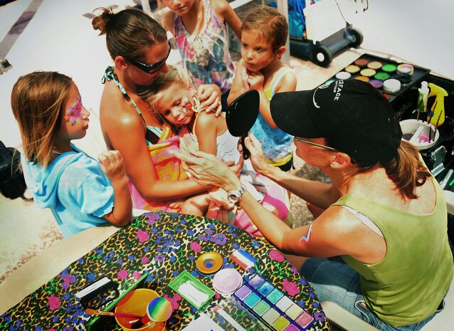Held by her mother Vanessa Drew, Natalie Drew gazes in a mirror as children gather round to see her finished face painting at the base pool on Joint Base Charleston, S.C., Aug. 28, 2010. The kaleidoscope of paints was an instant hit at the finale, producing bright eyes and colorful cheeks for children playing in the summer heat. Vanessa is the wife of U.S. Air Force Staff Sgt. Matthew Drew who is a weather forecaster with the 437th Operations Support Squadron. (U.S. Air Force photo/Staff Sgt. Daniel Bowles)