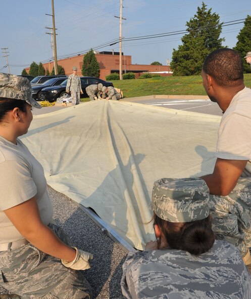 100827-F-4406D-032 SHAW AIR FORCE BASE, S.C.--    Senior Airman Edna Padilla, Staff Sgt. Stephanie Farrell , and Airman 1st Class Curtis Crum 20th Force Support Squadron personnel contingency operations help tighten the bottom liner for a tent being built in front of the Chandler Deployment Processing Center in preparation for Phase I of Exercise Sea Lion 10-07 Aug. 27, 2010. Exercises are held periodically to mentally and physically prepare Airmen for combat situations. (U.S. Air Force photo/ Airman 1st Class Tabatha L. Duarte)