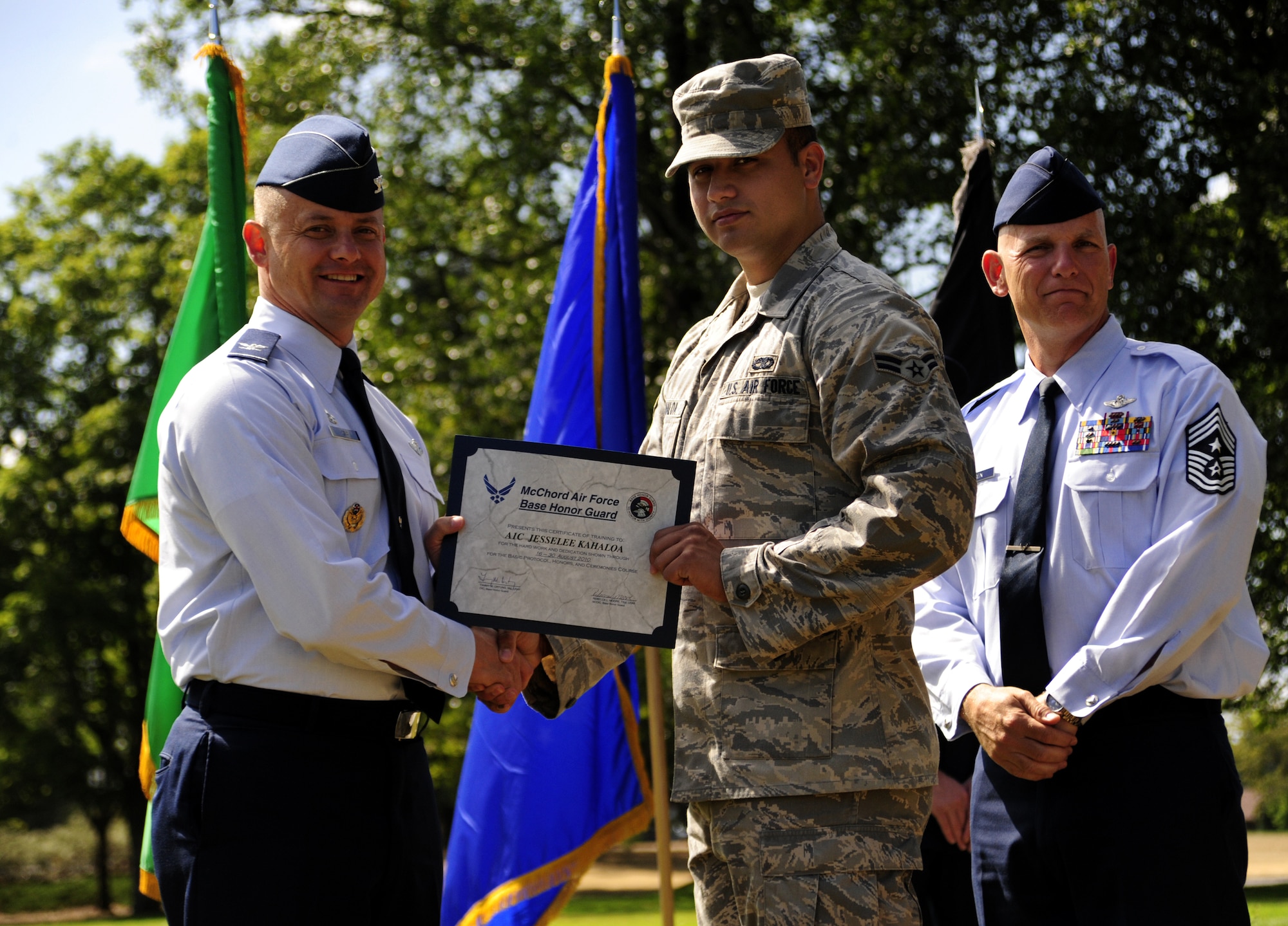 Col. Kevin Kilb, 62nd Airlift Wing commander, and Chief Master Sgt. Gregory Warren, 62nd Airlift Wing command chief, congradulate Airman 1st Class Jesselee Kahaloa, assigned to the 62nd Aircraft Maintenance Squadron, during an Honor Guard graduation ceremony Aug. 30 at Joint Base Lewis-McChord, Wash. (U.S. Air Force Photo/Airman Leah Young)