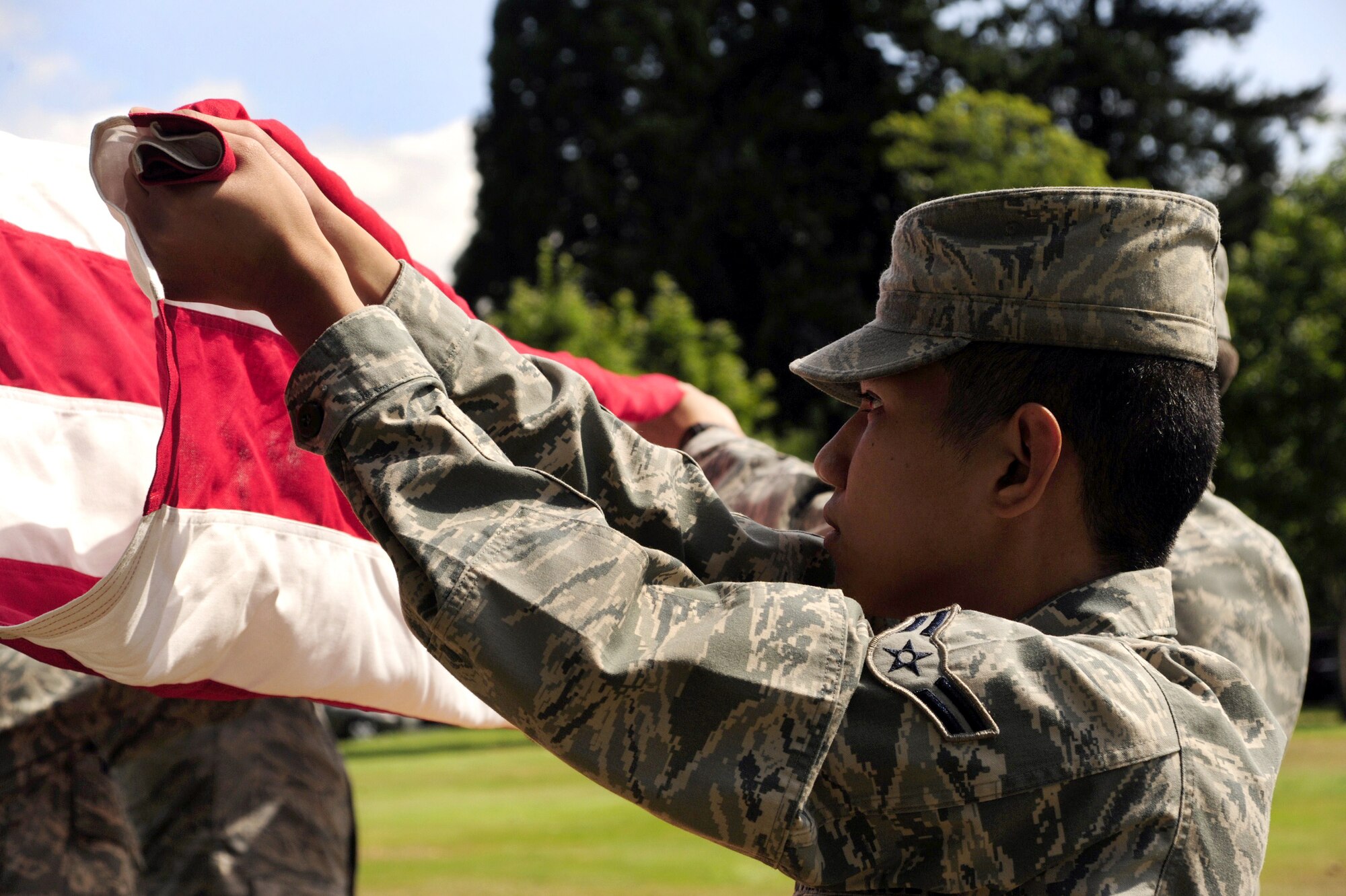 Airman 1st Class Anthony Alano, assigned to the 62nd Communications Squadron, participates in a flag folding detail during an Honor Guard graduation ceremony Aug. 30 at Joint Base Lewis-McChord, Wash. (U.S. Air Force Photo/Airman Leah Young)
