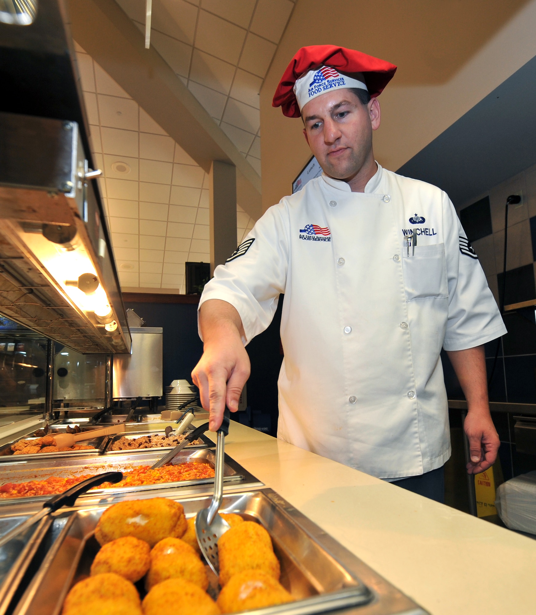 Tech. Sgt. David Winchell, 19th Force Support Squadron dining facility shift leader, serves chicken cordon bleu Aug. 26 to members of Team Little Rock. The dining facility serves more than 21,500 meals each month to servicemembers. (U.S. Air Force photo by Staff Sgt. Chris Willis)
