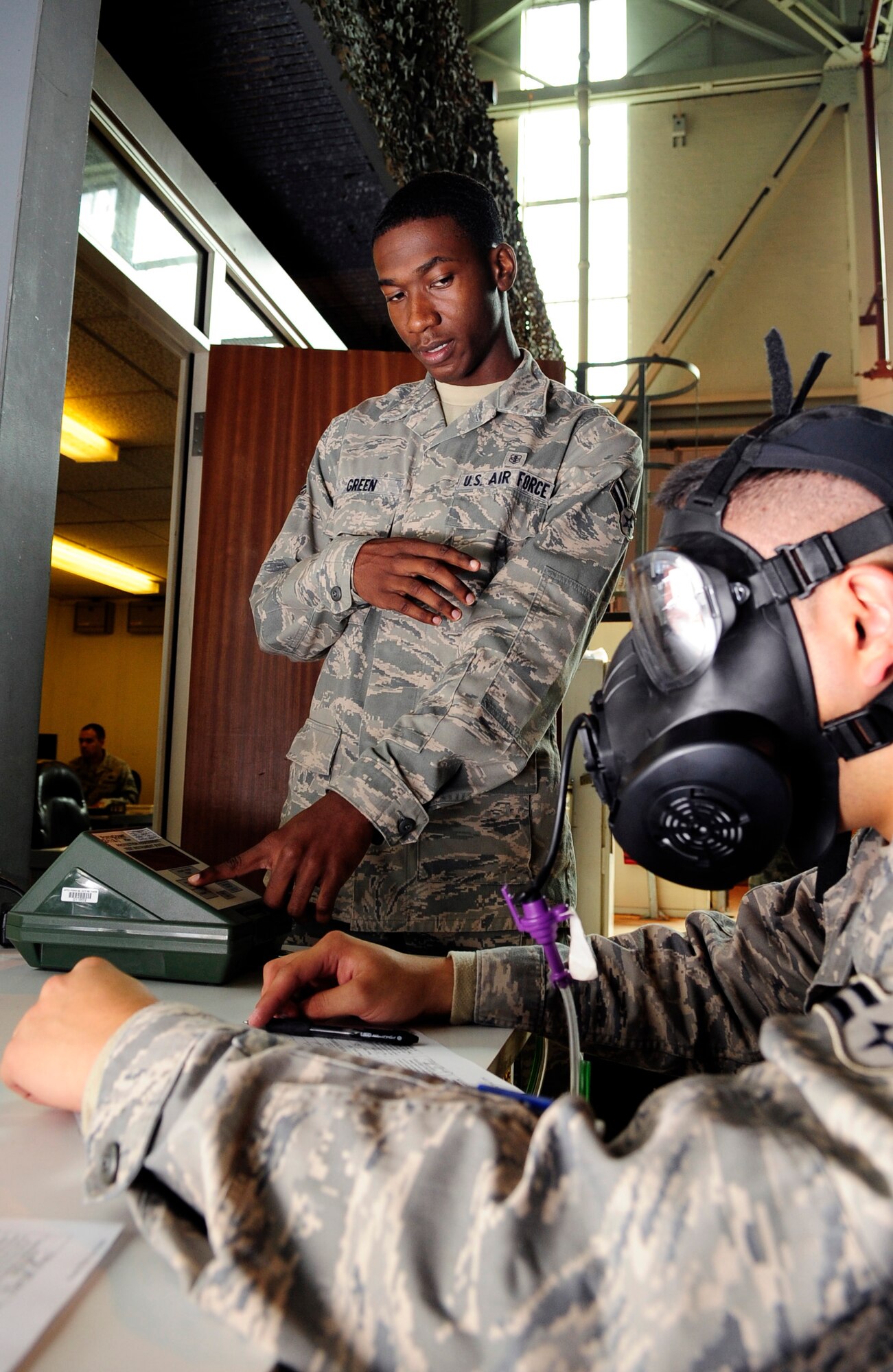 RAF MILDENHALL, England -- Airman 1st Class Jeramie Green, 48th Aerospace Medical Dental Squadron bioenvironmental technician, administers a gas mask fit test to Airman 1st Class Miguel Flores, 352nd Special Operations Maintenance Squadron electronic warfare apprentice, here Aug. 31. The gas mask fit tests help to ensure each gas mask meets every individual's needs to keep them safe. (U.S. Air Force photo/Senior Airman Ethan Morgan)