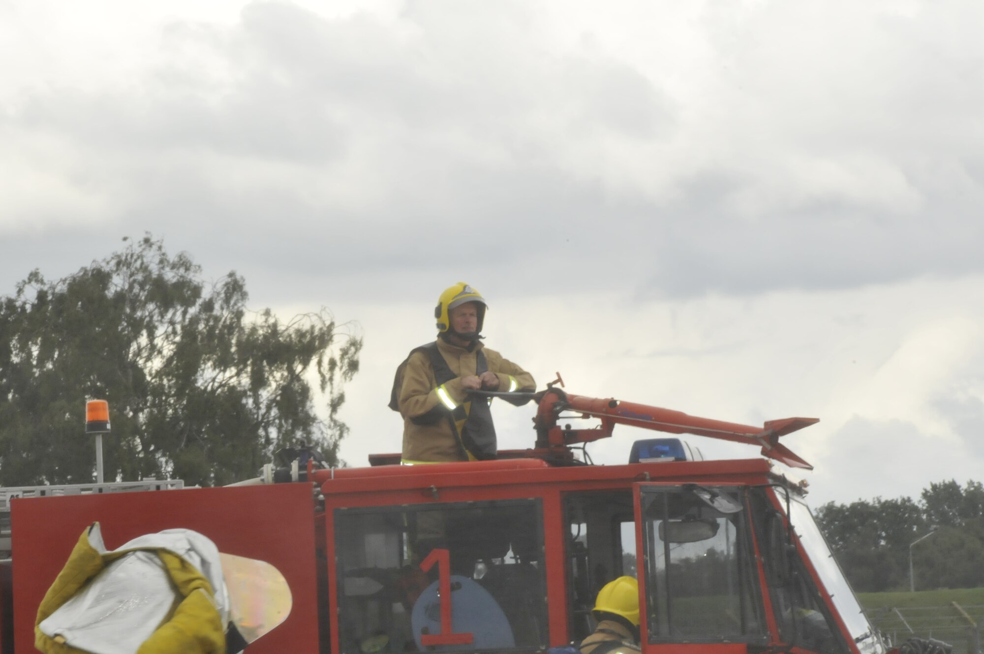 Chris Groom, Ministry of Defense firefighter, from RAF Wattisham operates a top mounted water gun during fire training using a controlled burning F-15 at RAF Lakenheath, England, Aug. 27. This was the first time MOD firefighters trained with the RAF Lakenheath simulator. (U.S. Air Force photo/Airman 1st Class Eboni Knox)