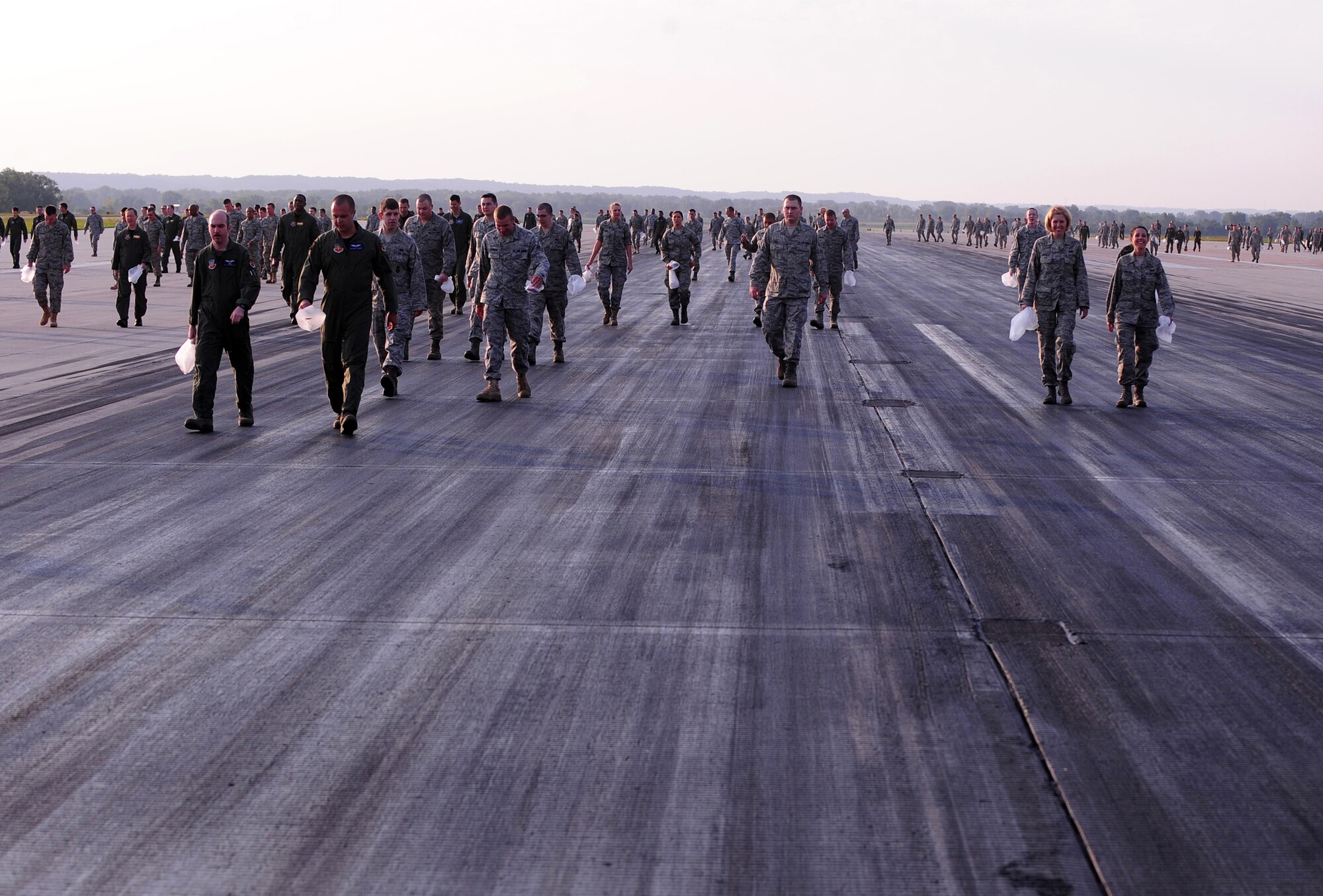 OFFUTT AIR FORCE BASE, Neb. - Hundreds of 55th Wing members walk down the runway here Aug. 30 collecting trash and debris during a foreign object debris walk following the 2010 Defenders of Freedom Air Show and Open House. The early morning FOD walk allowed aircraft operations to begin here safely. U.S. Air Force photo by Josh Plueger