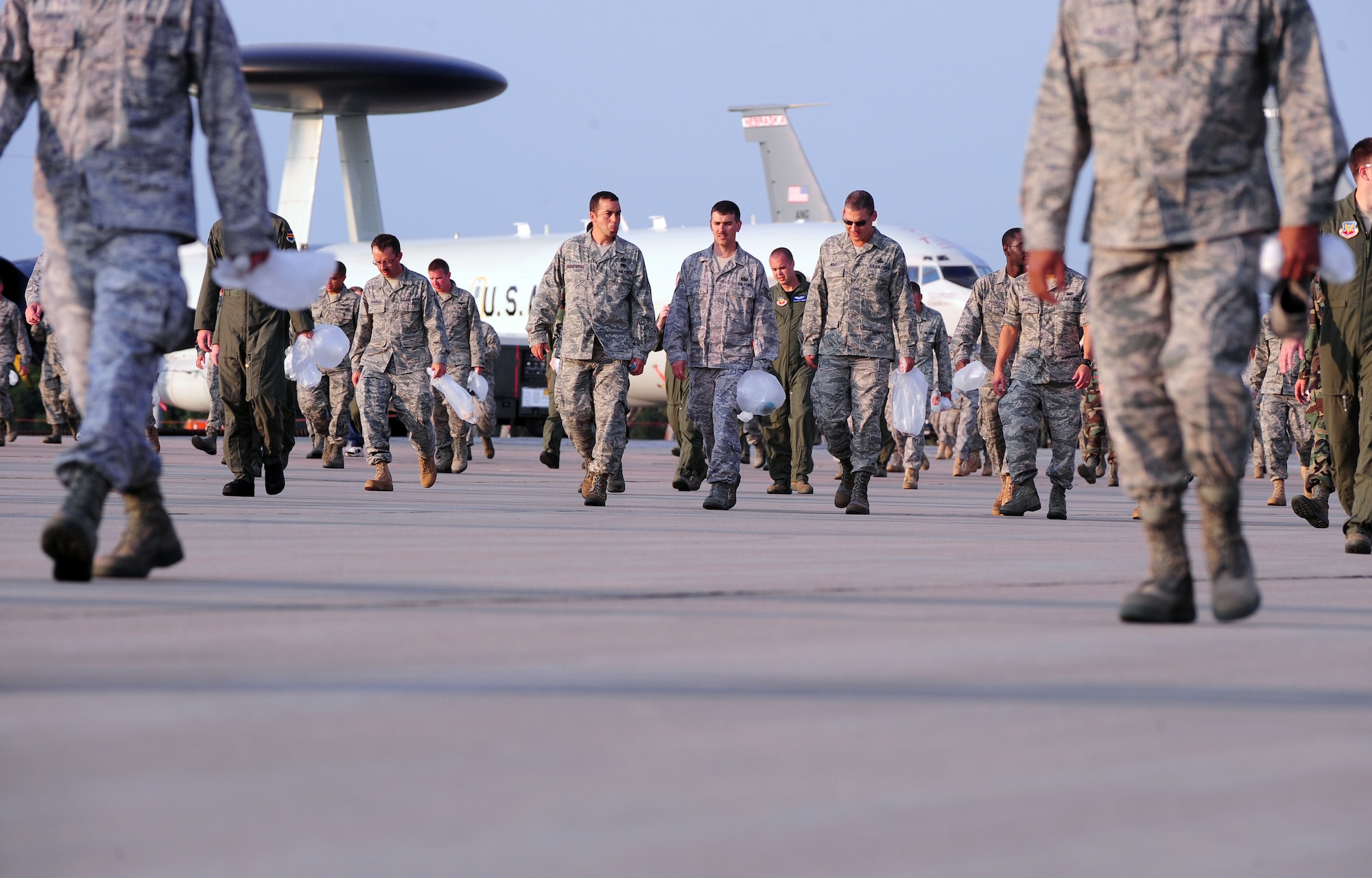 OFFUTT AIR FORCE BASE, Neb. - Hundreds of 55th Wing members walk down the runway here Aug. 30 collecting trash and debris during a foreign object debris walk following the 2010 Defenders of Freedom Air Show and Open House. The early morning FOD walk allowed aircraft operations to begin here safely. U.S. Air Force photo by Josh Plueger