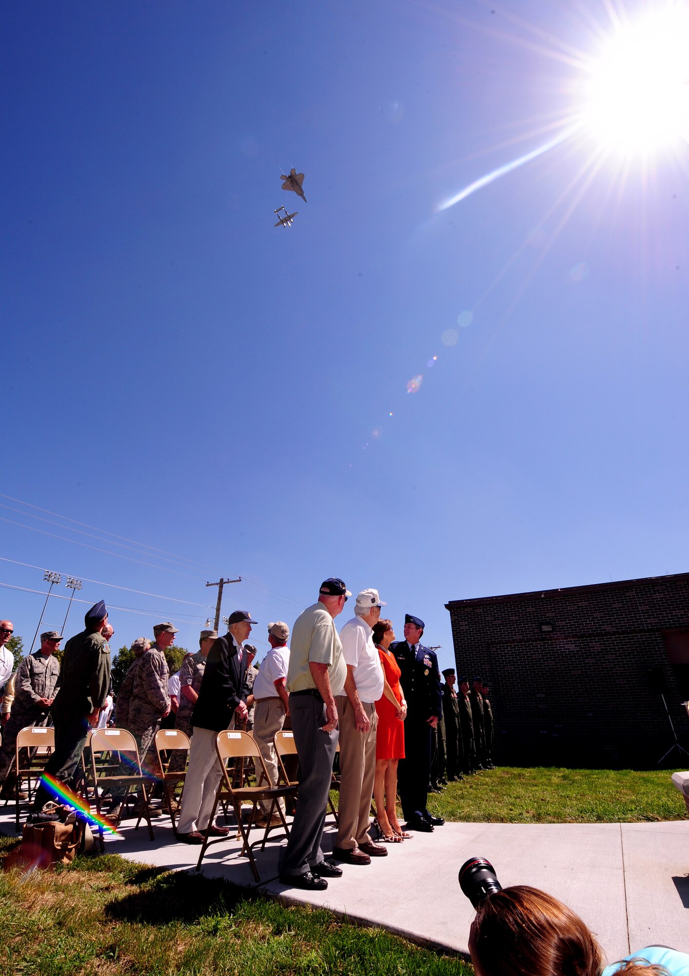 OFFUTT AIR FORCE BASE, Neb. - An F-22 Raptor and P-38 Lightning fly in formation over a plaque rededication ceremony in honor of the 55th Fighter Group, Aug. 27.  The plaque, outside of the 55th Wing and 55th Operations Group headquarters building, honors the heroic efforts of the fighter group. U.S. Air Force photo by Josh Plueger
