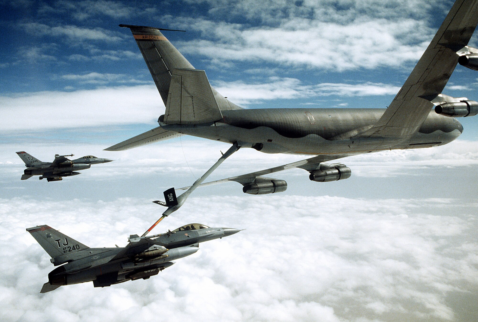 A 401st Tactical Fighter Wing F-16C Fighting Falcon aircraft refuels from a KC-135 Stratotanker aircraft as another F-16 stands by during Operation Desert Storm.  
