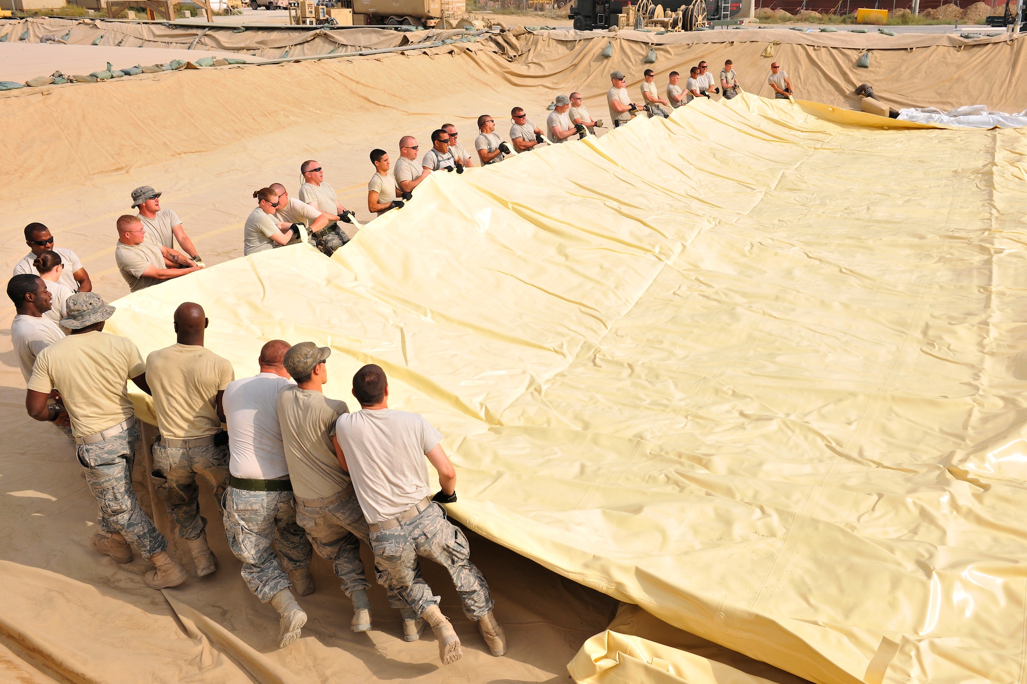 Airmen assigned to the 455th Expeditionary Logistics Readiness Squadron unfurl a new fuel bladder at Bagram Airfield, Afghanistan, Aug. 31. 2010. The new fuel bladder can hold 200,000 gallons of jet fuel.  (U.S. Air Force photo/Staff Sgt. Christopher Boitz)