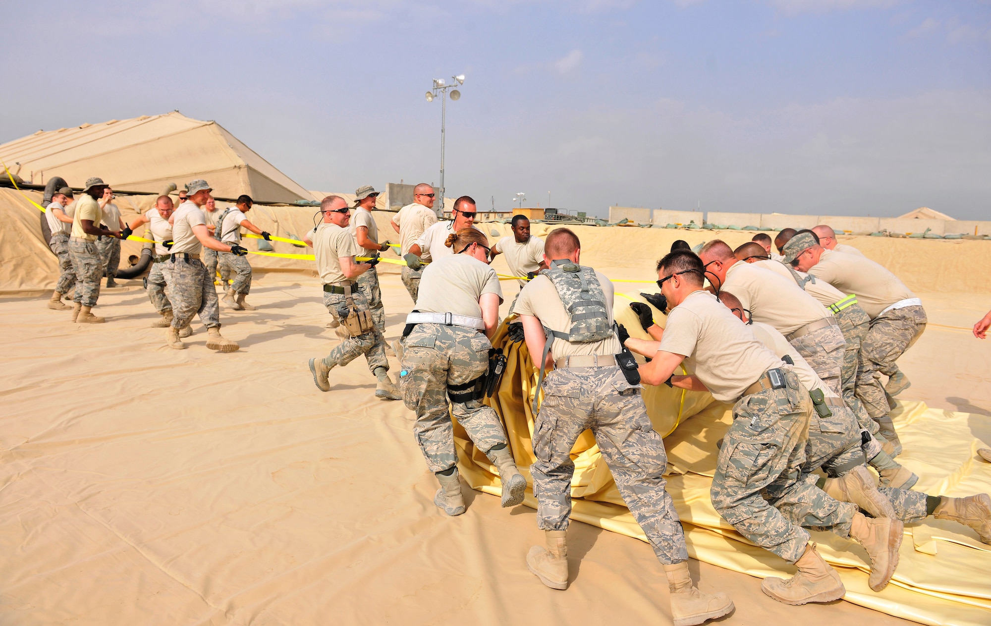 Airmen assigned to the 455th Expeditionary Logistics Readiness Squadron unfurl a new fuel bladder at Bagram Airfield, Afghanistan, Aug. 31. 2010. The new fuel bladder can hold 200,000 gallons of jet fuel.  (U.S. Air Force photo/Staff Sgt. Christopher Boitz)