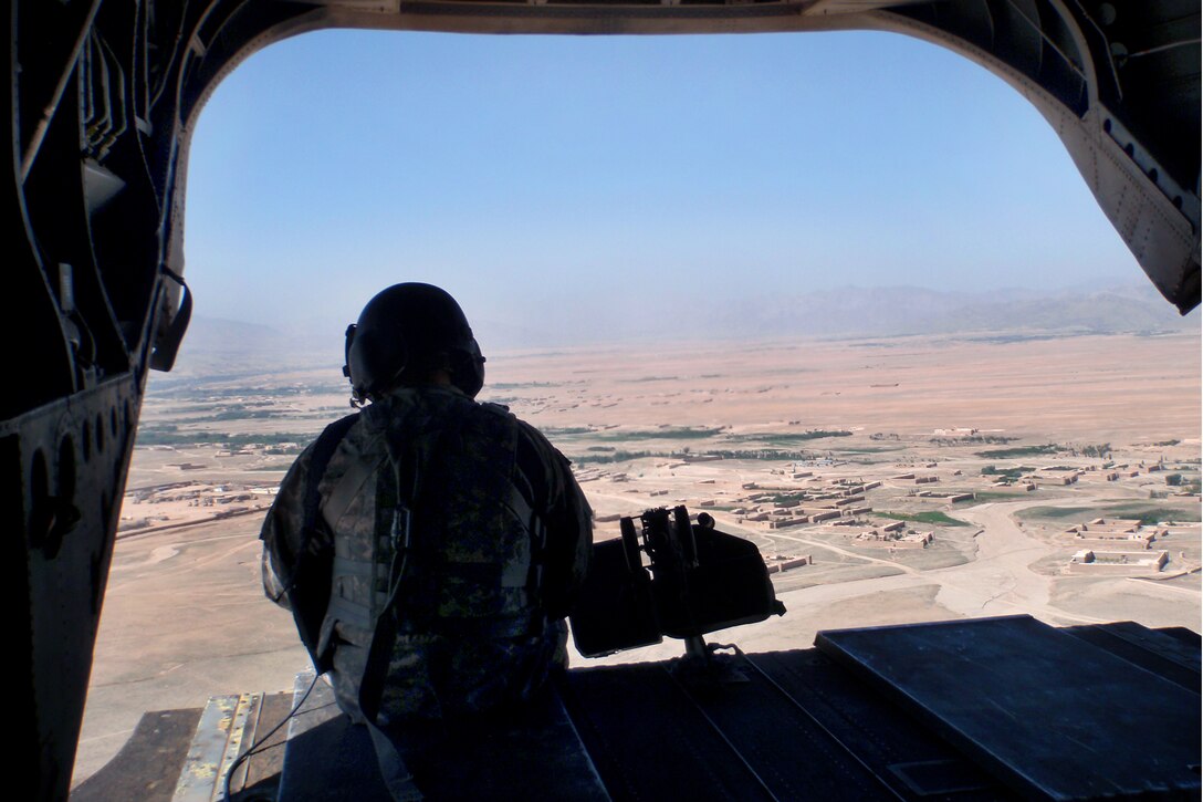 A U.S. Army crew chief aboard a CH-47 Chinook helicopter mans an M-240B machine gun after an extraction operation in the Jaghatu district, Wardak province, Afghanistan, Aug. 21, 2010. The soldier is assigned to the 1st Battalion, 503rd Infantry Regiment, 173rd Airborne Brigade Combat Team.