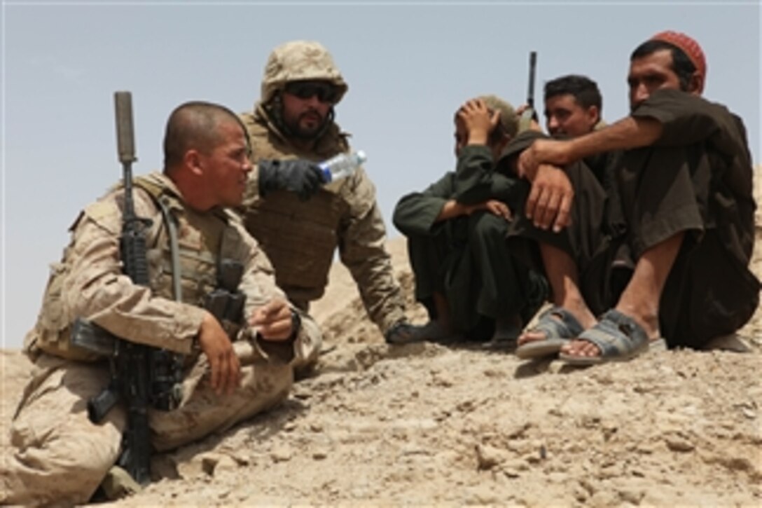 U.S. Marine Corps Gunnery Sgt. Nelson Martinez (left) with Weapons Company, 3rd Battalion, 7th Marine Regiment and an interpreter speak with Afghan men during a presence patrol in eastern Sangin district, Helmand province, Afghanistan, on Aug. 9, 2010.  