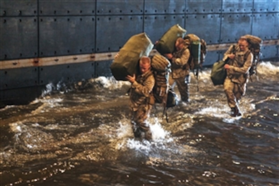 U.S. Marines walk through water in the well deck of the amphibious assault ship USS Kearsarge while the ship is stationed off Camp Lejeune, N.C., Aug. 28, 2010. The Marines, assigned to the 26th Marine Expeditionary Unit, deployed aboard the ships of the Kearsarge Amphibious Ready Group to support Pakistan flood relief efforts.