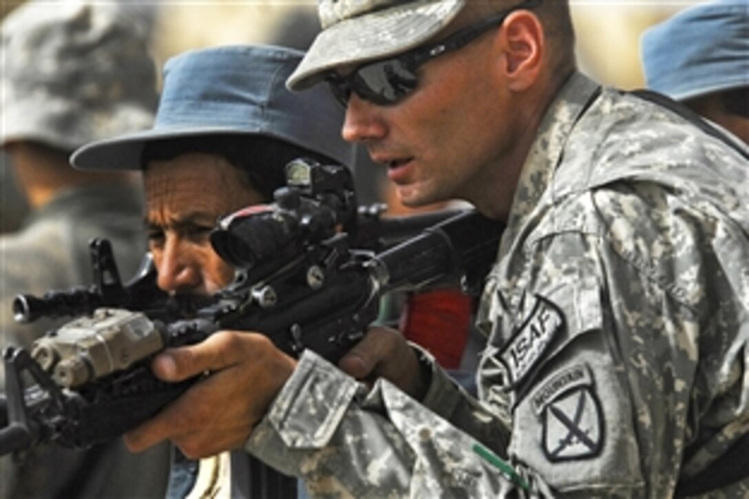 U.S. Army Sgt. James Henderson, right, assists an Afghan police officer during call-out training at the police headquarters in Chahar Dara, Afghanistan, Aug. 28, 2010. Henderson is assigned to the 10th Mountain Division.