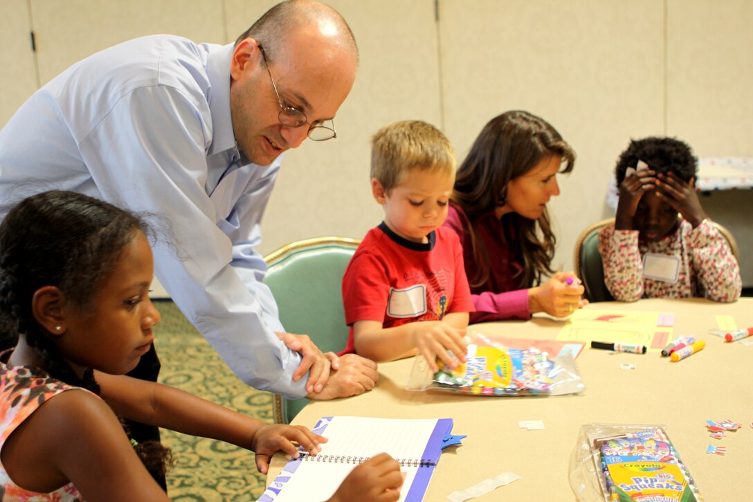 Tom Babayan and Tami Patton, both Families OverComing Under Stress project trainers, Family Readiness Center, Camp Pendleton, help children learn about deployment during a “Warrior Kids Workshop” sponsored by Camp Pendleton’s Marine Corps Family Team Building. The workshop is a three-part program for children ages 5-12 that help them cope with various deployment issues.