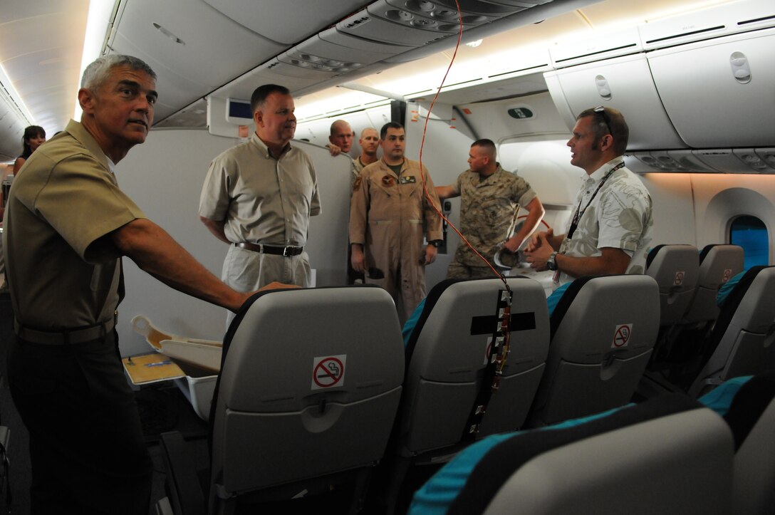 Monte Martin, Boeing test director, speaks with air station personnel including Greg McShane, airfield operations officer, and new station operations officer, Lt. Col. Charles K. Carroll, left, in the cabin of an experimental version of the Boeing 787 Dreamliner testing at the Yuma International Airport's Defense Contractor Complex on the other side of the air station’s flight line Sept. 1, 2010. Being tested in Yuma due to the high temperatures, the airplane is built primarily of lighter composite materials reducing fuel consumption by 20 percent. Testing is expected to continue in Yuma until mid-September, and is expected to be in service by early 2011, said Martin.