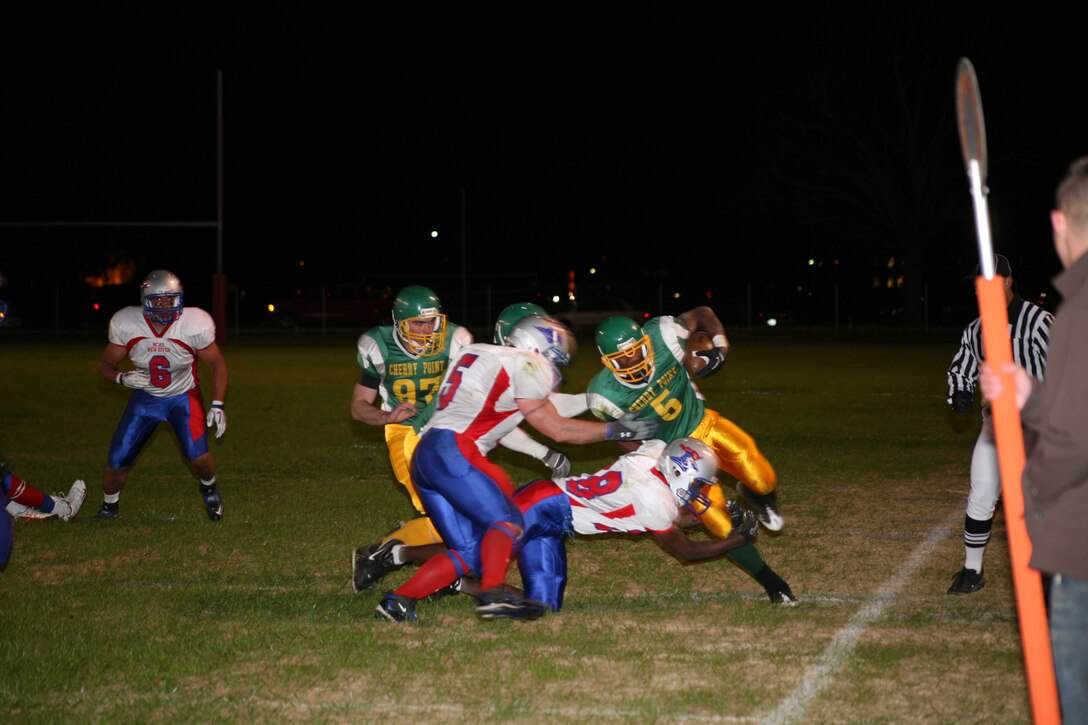 Donald Lewis runs the ball past the Marine Corps Air Station New River defense on the way to a fourth- quarter victory in the Regional Intramural Football Championship game held at Marine Corps Base Camp Lejeune, Dec. 1. The Cherry Point Eagles trailed New River 8-28 headed into the fourth quarter and scored 22 unanswered points to win their first championship since 2006, 30-28.