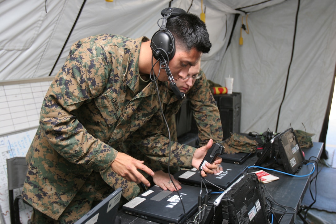 Lance Cpls. Byron Garcia and Andrew Beckett test the equipment for the Direct Air Support Center behind the Marine Air Control Group 28 headquarters Dec. 1. The Marines will be participating in the Marine Air Command and Control System Integrated Simulated Training Exercise Dec. 14-16 that will test the abilities of MACG-28 and subordinate units before deploying to Afghanistan.