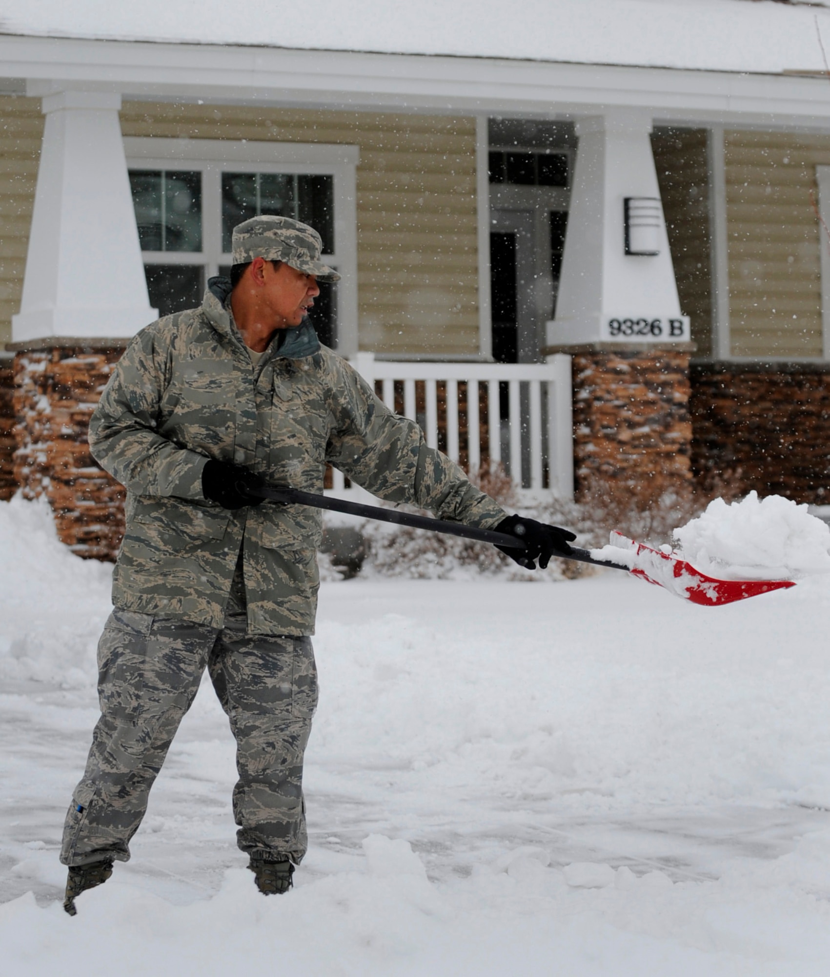 MOUNTAIN HOME AIR FORCE BASE, Idaho -- Tech. Sgt. Richie Videna, 389th Aircraft Maintenance Unit avionics specialist, shovels snow in his yard Dec. 1. Due to the inclement weather and bad road conditions Airmen were permitted late reporting and early release. (U.S. Air Force photo by Senior Airman Renishia Richardson)