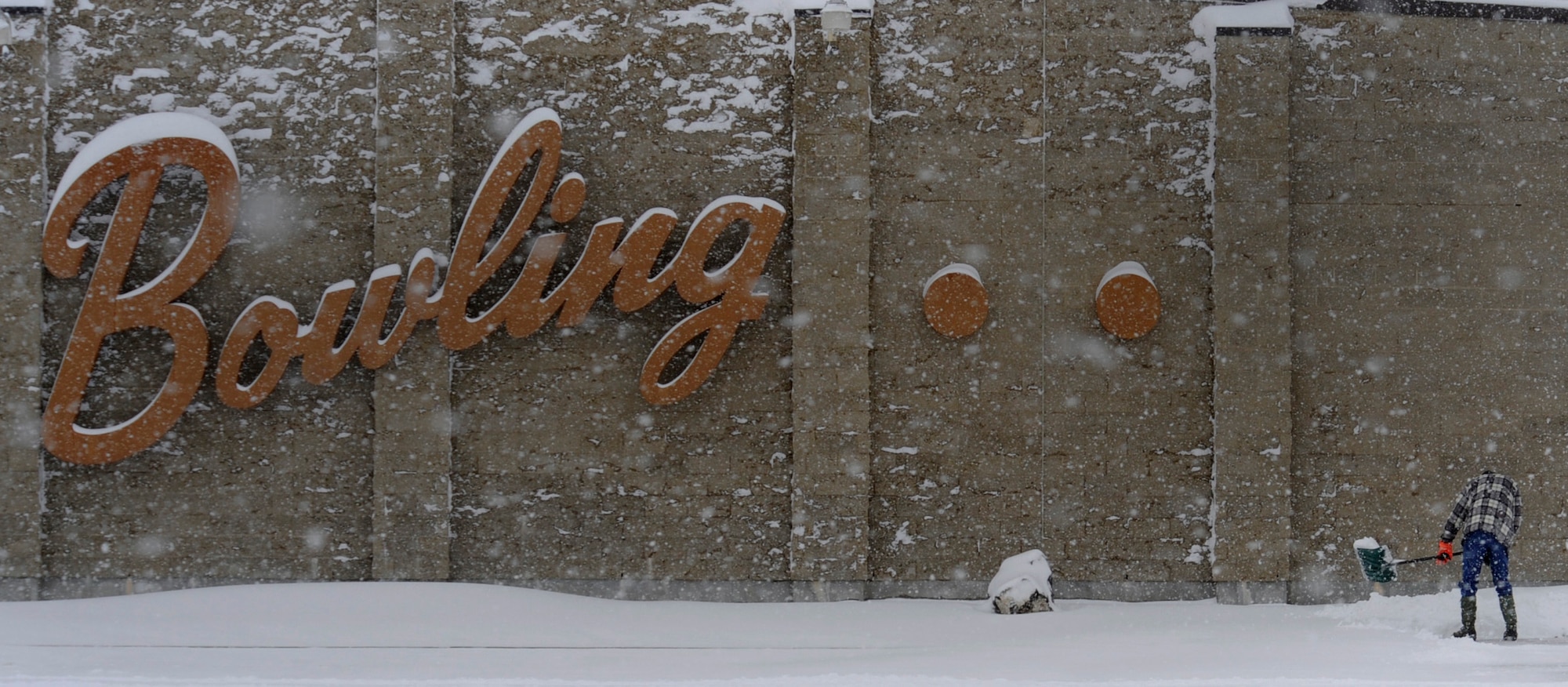 MOUNTAIN HOME AIR FORCE BASE, Idaho -- A staff member from the Bowling Alley shovels snow Dec. 1. Due to the inclement weather and bad road conditions Airmen were permitted late reporting and early release. (U.S. Air Force photo by Senior Airman Renishia Richardson)