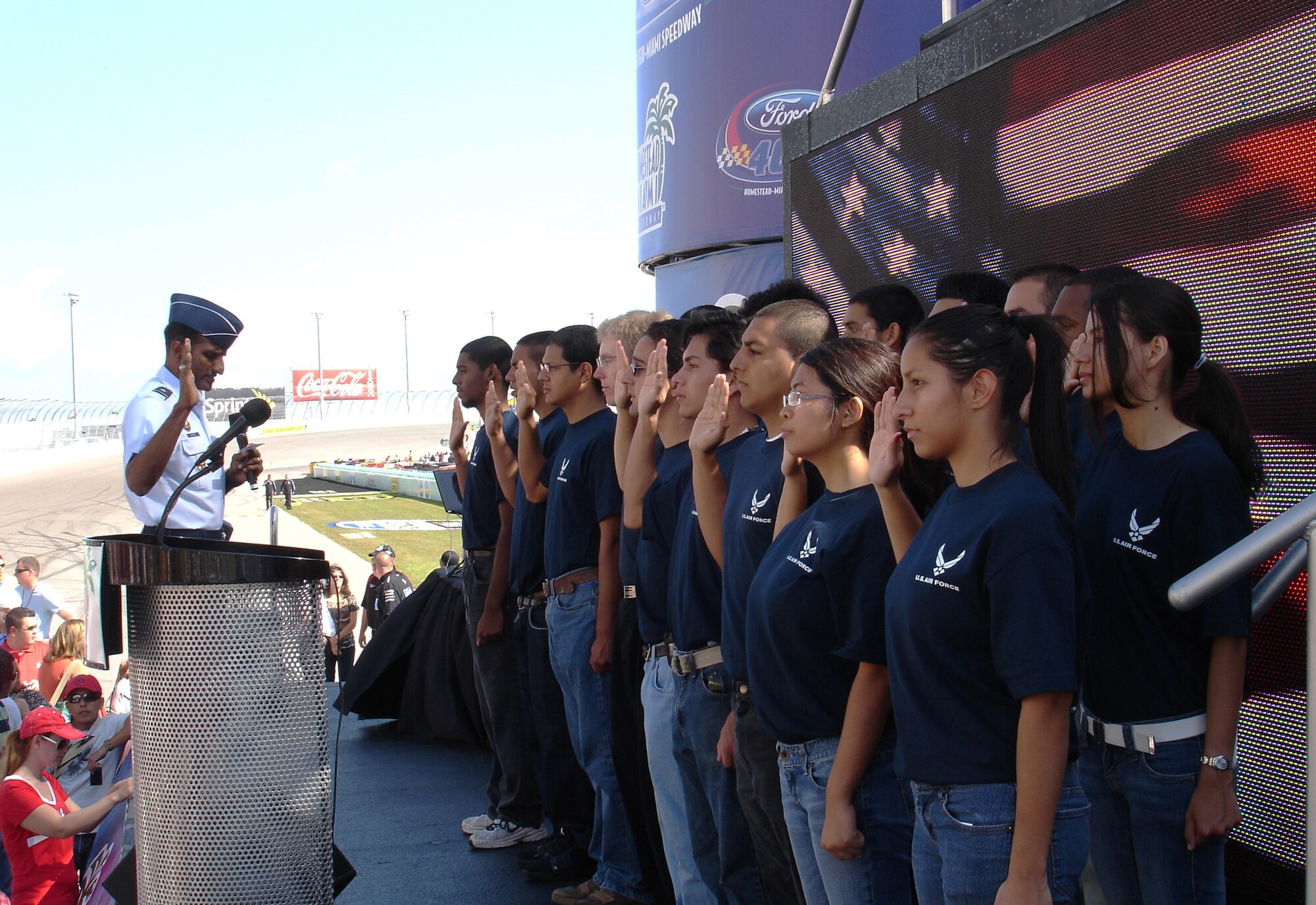 Brig. Gen. Balan R. Ayyar, commander of Air Force Recruiting Service, swears in more than 20 future Airmen at Homestead-Miami International Speedway Nov. 21, 2010, in front of more than 50,000 fans before the start of NASCAR's Ford 400 Championship Weekend Race. The 333rd Recruiting Squadron coordinated the ceremony and other events, featuring Elliott Sadler, driver of the Air Force No. 19 car. Mr. Sadler signed autographs and greeted future Airmen, recruiters and fans at the 333rd RCS recruiting booth. The pre-race show culminated with a fly-over of four F-16 Fighting Falcons. (U.S. Air Force photo/Master Sgt. Rebecca Ewertz) 